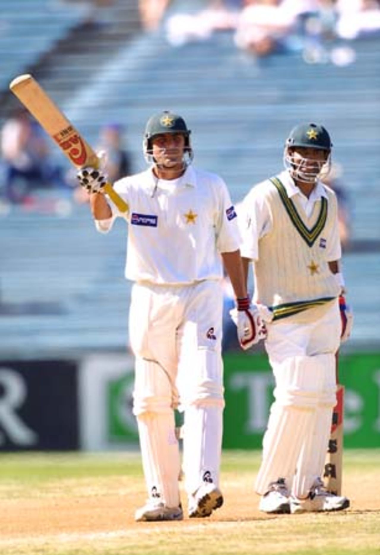 Pakistan batsman Younis Khan raises his bat in celebration of reaching 50 in his second innings, while batting partner Yousuf Youhana looks on. Younis went on to score 149 not out, his third Test century in his 10th Test. 1st Test: New Zealand v Pakistan at Eden Park, Auckland, 8-12 March 2001 (11 March 2001).