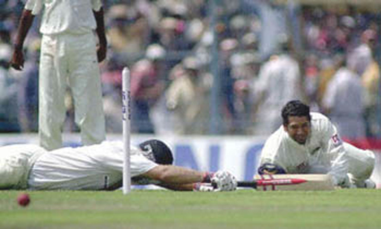 11 March 2001: Australian batsman Matt Hayden ( L) lies flat on the ground after making his crease in the nick of time on the first day of the second test match between India and Australia at Eden Gardens in Calcutta.