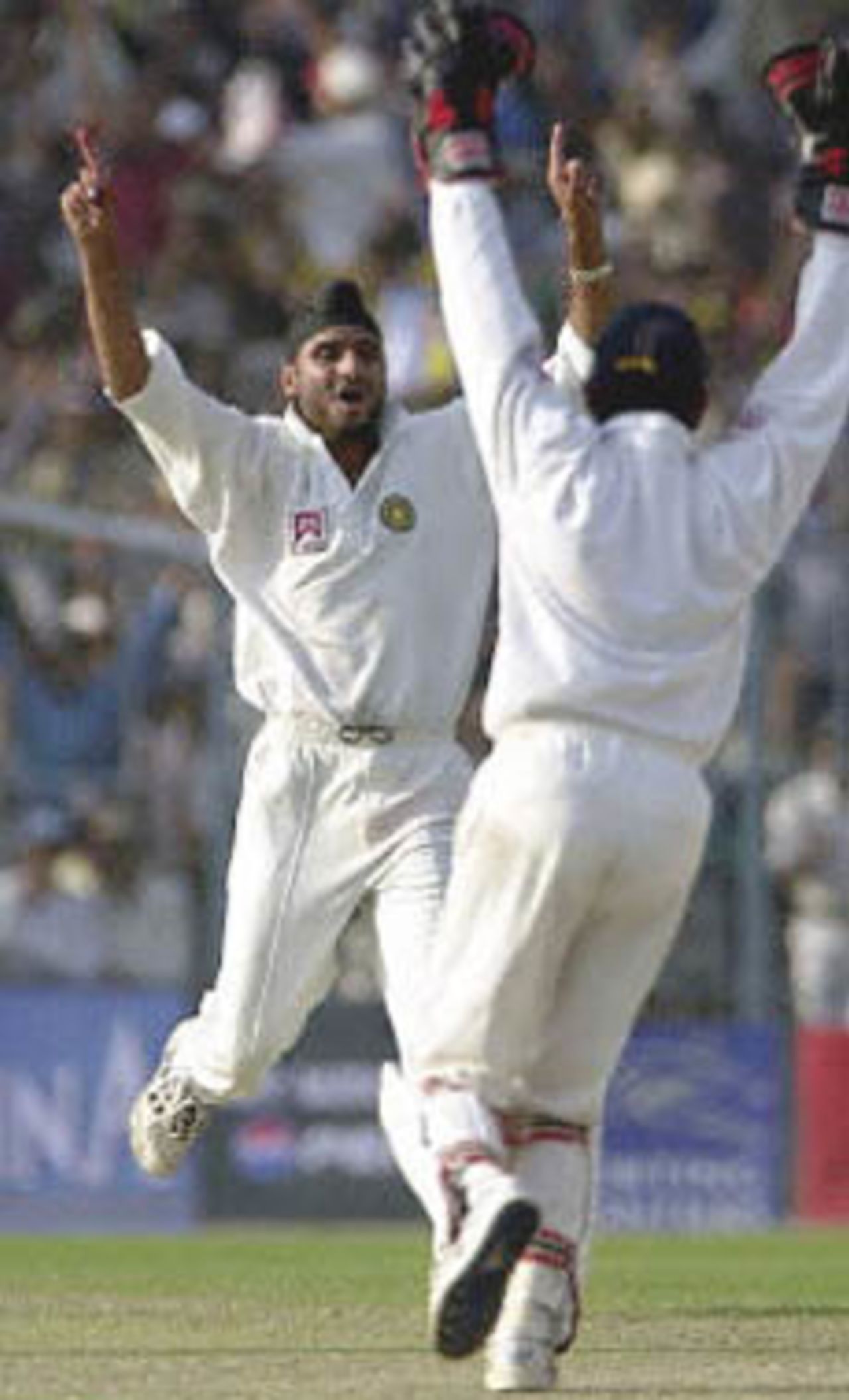 11 March 2001: Indian spinner Harbhajan Singh and team-mate Nayan Mongia celebrate after Singh claimed Australian player Shane Warne to complete a hat-trick on the first day of the second test match between India and Australia at Eden Gardens in Calcutta.