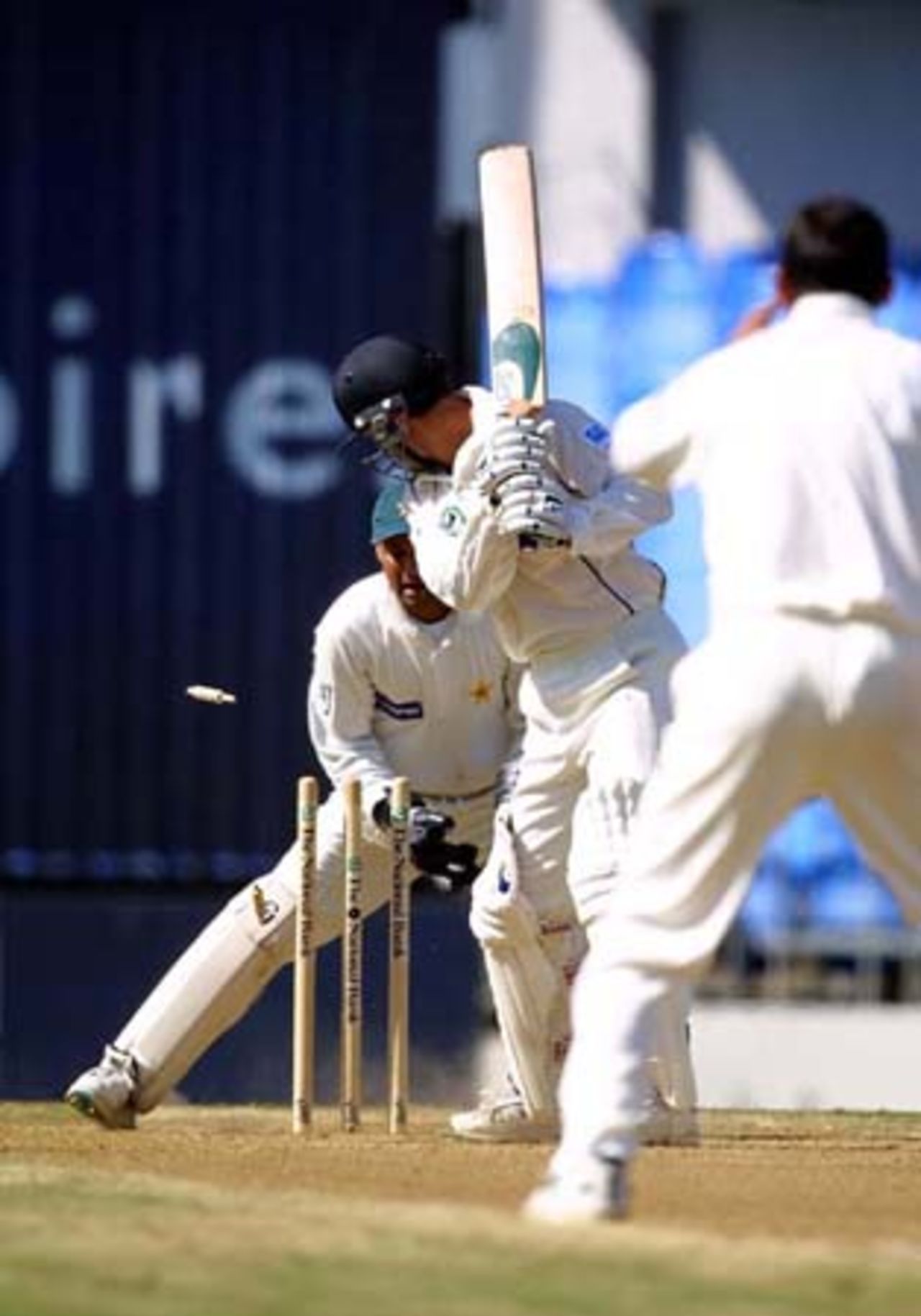 New Zealand batsman Nathan Astle looks back to see the stumps rattled as he is bowled by Pakistan off spinner Saqlain Mushtaq for one. Wicket-keeper Moin Khan looks on. 1st Test: New Zealand v Pakistan at Eden Park, Auckland, 8-12 March 2001 (12 March 2001).