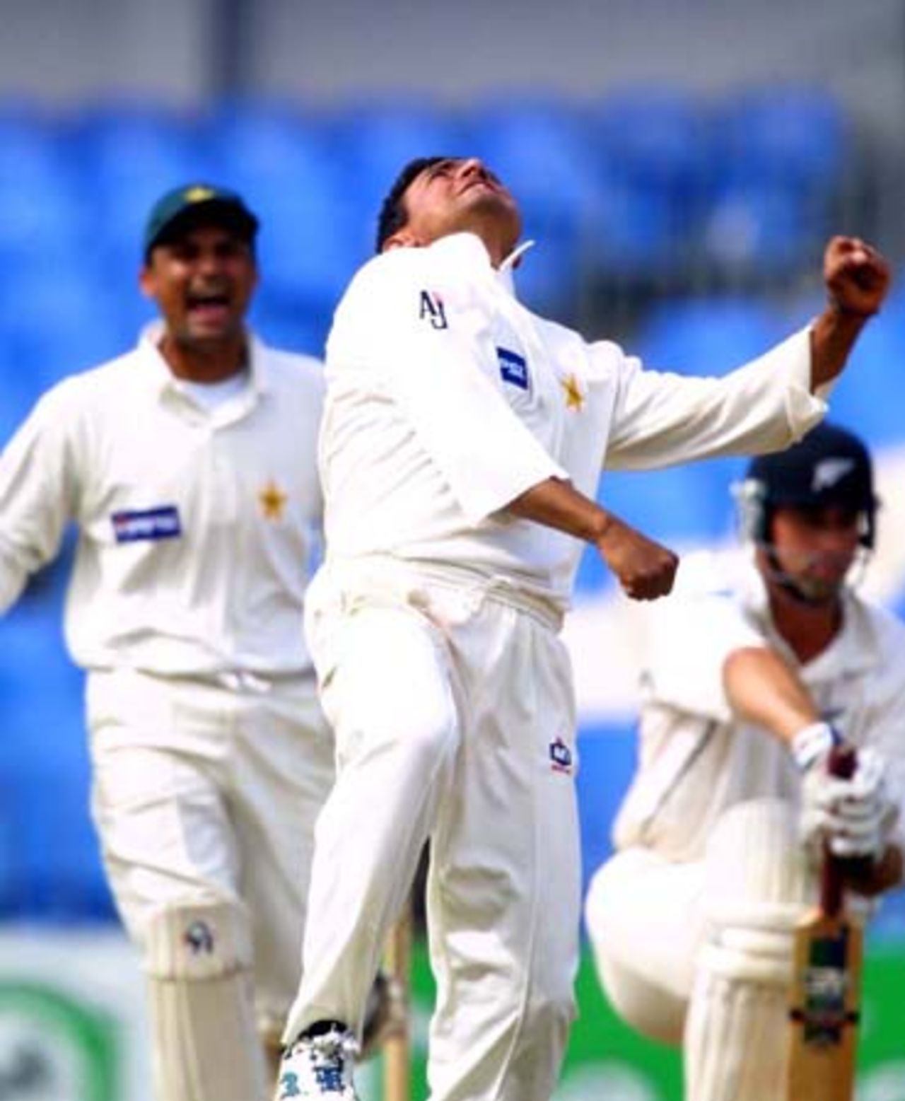 Pakistan off spinner Saqlain Mushtaq (centre) celebrates the dismissal of New Zealand batsman Stephen Fleming (right), leg before wicket for five. Wicket-keeper Moin Khan approaches down the wicket to join the celebration. Saqlain took 4-24 from 25.4 overs in New Zealand's second innings to help complete a 299-run victory. 1st Test: New Zealand v Pakistan at Eden Park, Auckland, 8-12 March 2001 (12 March 2001).