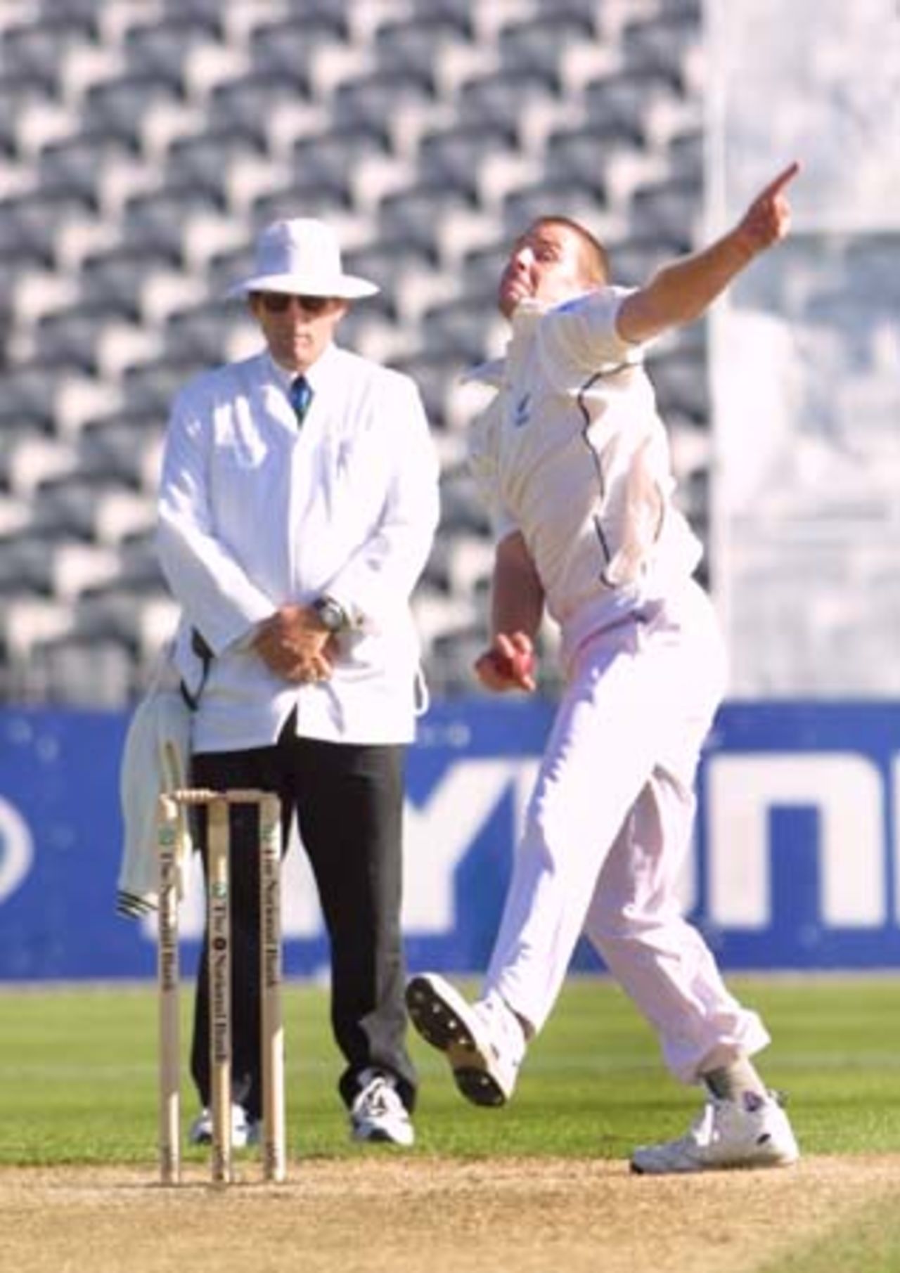 Debutant New Zealand fast medium Chris Drum delivers a ball while umpire Dave Quested looks on. Drum ended the second day's play with first innings bowling figures of 1-7 from four overs. 2nd Test: New Zealand v Pakistan at Jade Stadium, Christchurch, 15-19 March 2001 (16 March 2001).