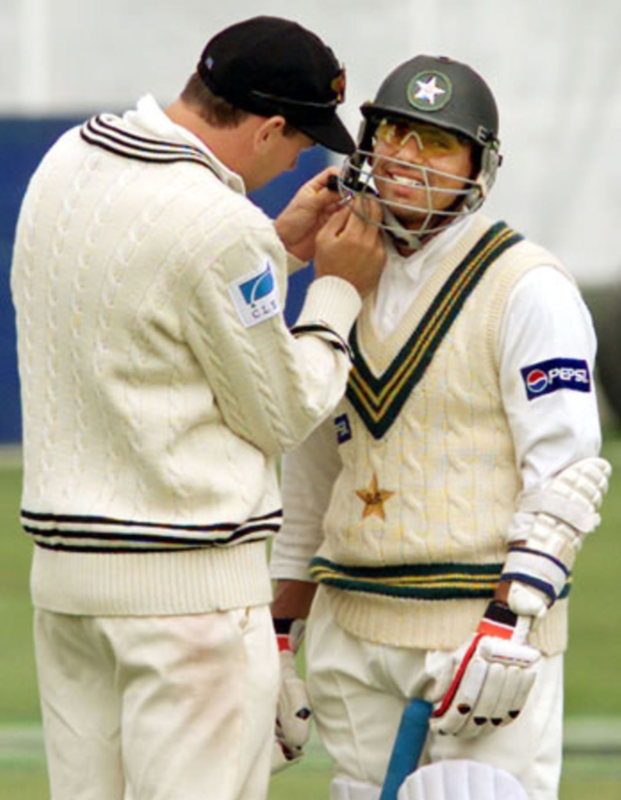 New Zealand fielder Stephen Fleming does up the chin strap of the helmet of Pakistan lower order batsman Saqlain Mushtaq. 2nd Test: New Zealand v Pakistan at Jade Stadium, Christchurch, 15-19 March 2001 (18 March 2001).