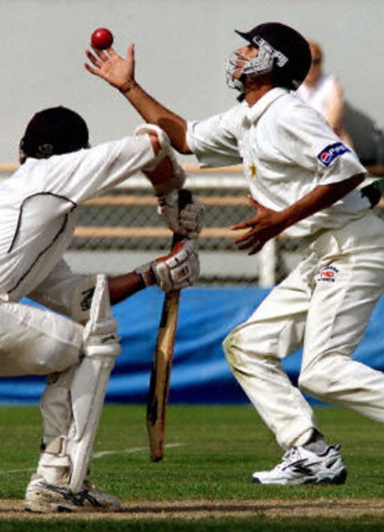 New Zealand batsman Mark Richardson (L) hits the ball to close-in Pakistan fielder Faisal Iqbal, day 5, 2nd Test at Christchurch, 15-19 March 2001