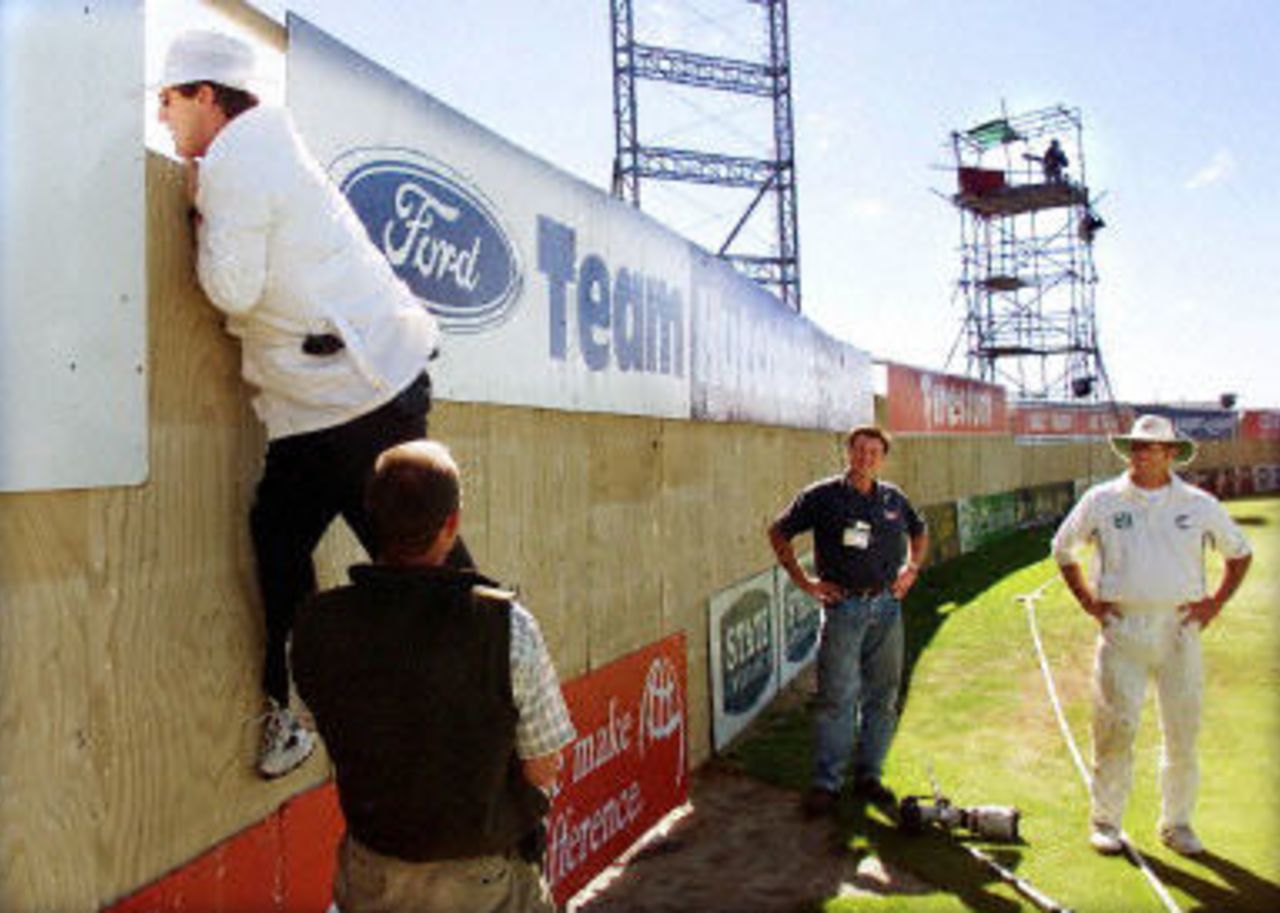 Umpire Dave Quested is given a leg-up by Christchurch Press photographer Don Scott to look for a ball hit for six by Saqlain Mushtaq as Reuters photographers Simon Baker and Mark Richardson look on, day 4, 2nd Test at Christchurch, 15-19 March 2001.