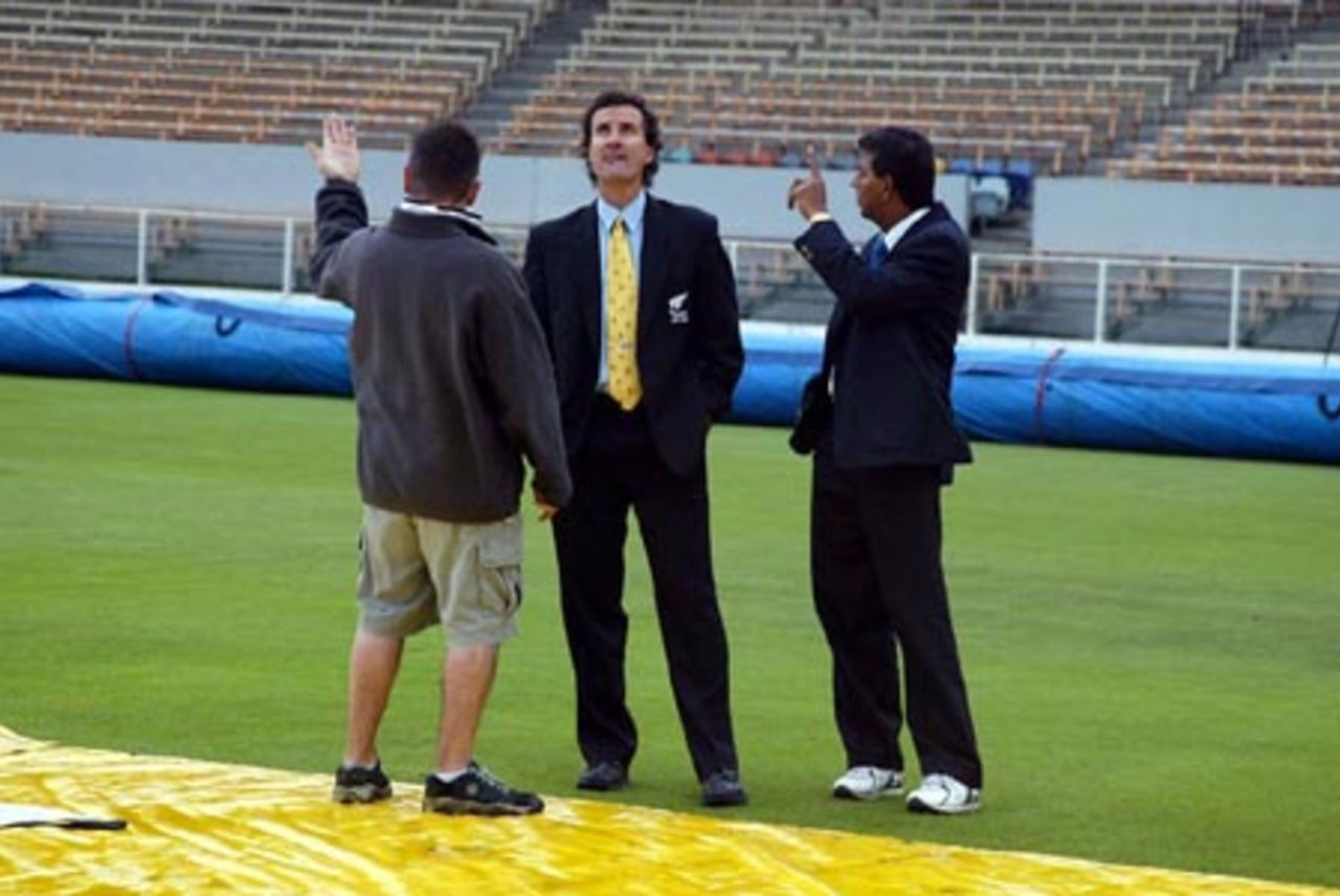 Head groundsman Chris Lewis (left) discusses the conditions with umpires Brent Bowden and Asoka de Silva from Sri Lanka as rain delays the start of play on day two. 1st Test: New Zealand v England at Jade Stadium, Christchurch, 13-17 March 2002 (14 March 2002).