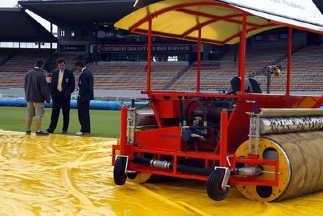 Umpires Brent Bowden (centre) and Asoka de Silva (right) from Sri Lanka inspect the ground with head groundsman Chris Lewis as rain delays the start of play on day two. 1st Test: New Zealand v England at Jade Stadium, Christchurch, 13-17 March 2002 (14 March 2002).