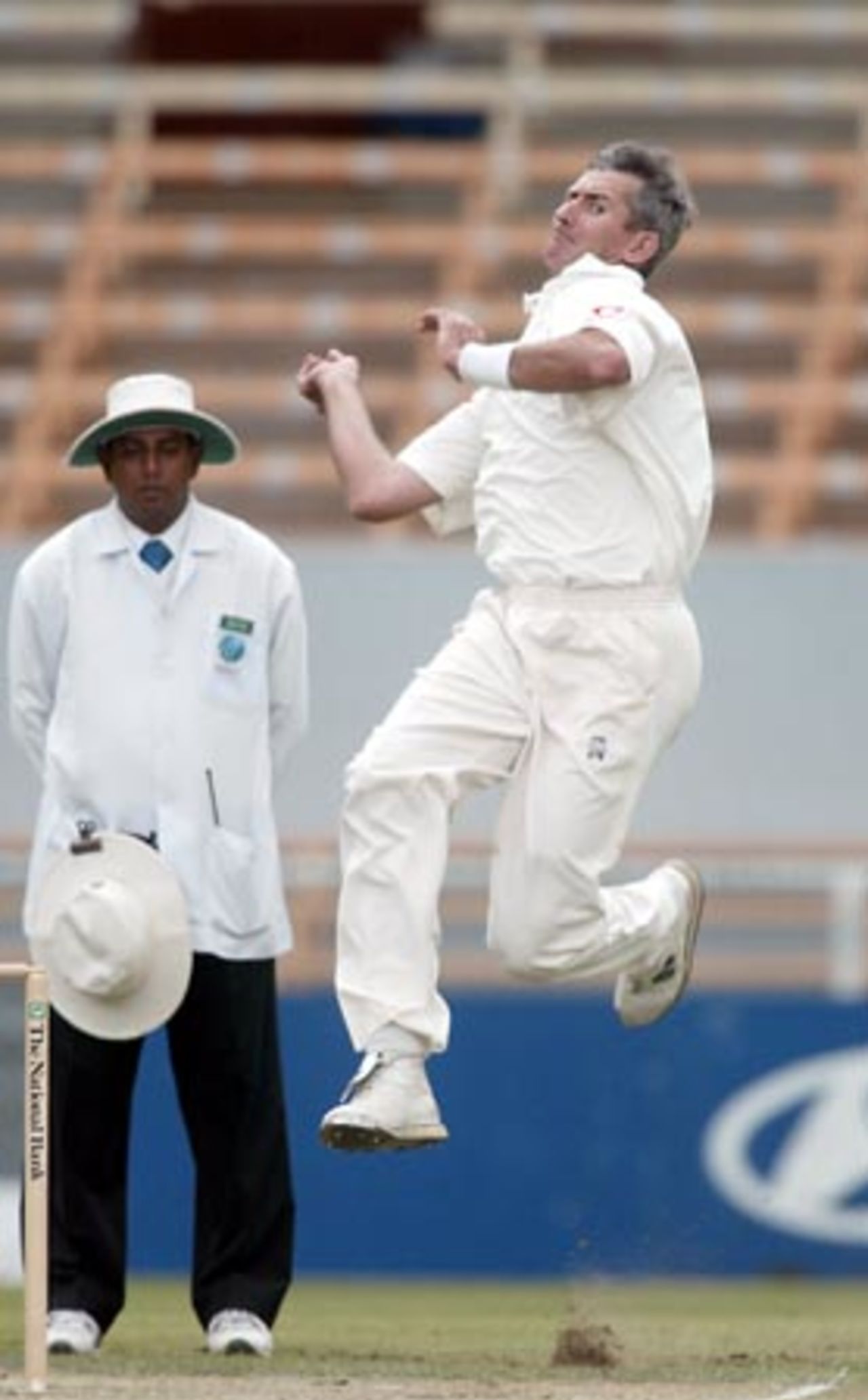 England bowler Andy Caddick delivers a ball during his second innings spell of 6-122 from 25 overs while umpire Asoka de Silva from Sri Lanka looks on. 1st Test: New Zealand v England at Jade Stadium, Christchurch, 13-17 March 2002 (16 March 2002).
