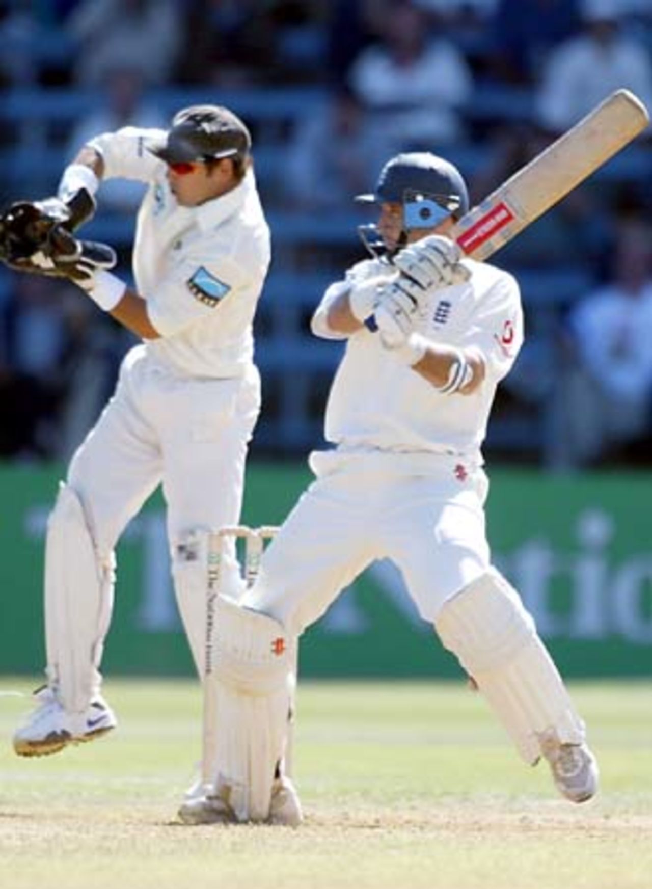 England batsman Nasser Hussain cuts a delivery from New Zealand bowler Daniel Vettori as wicket-keeper Adam Parore looks on. Hussain went on to score 66 in his first innings. 2nd Test: New Zealand v England at Basin Reserve, Wellington, 21-25 March 2002 (22 March 2002).