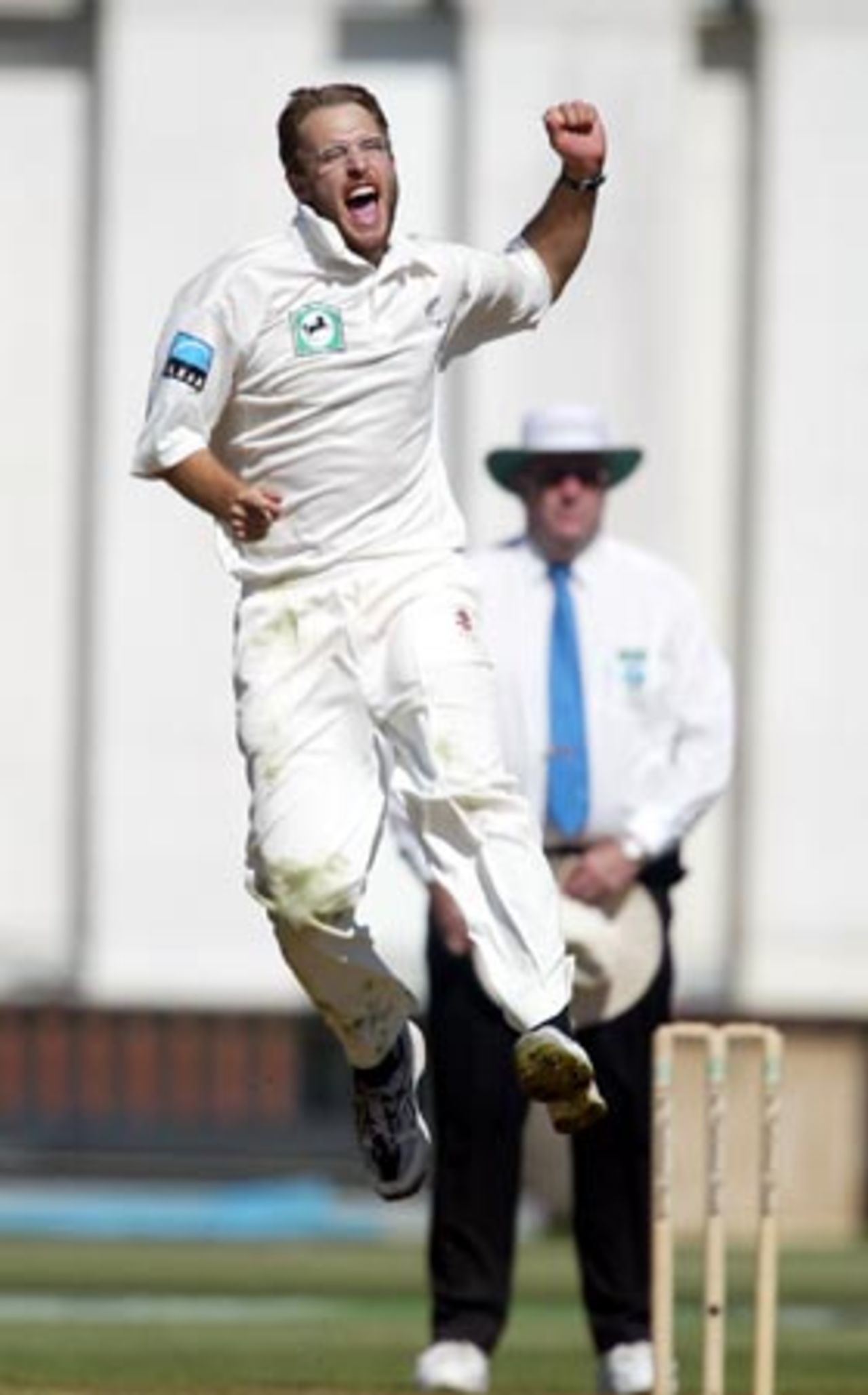 New Zealand bowler Daniel Vettori jumps to celebrate the dismissal of England batsman Nasser Hussain, caught by Nathan Astle for 66 in his first innings. Umpire Darrell Hair from Australia looks on in the background. 2nd Test: New Zealand v England at Basin Reserve, Wellington, 21-25 March 2002 (22 March 2002).