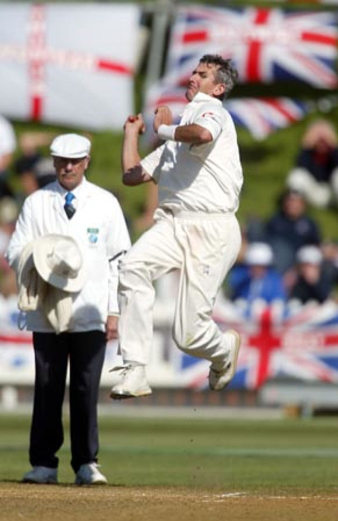 England bowler Andrew Caddick delivers a ball during his second innings spell of 0-31 from 17 overs as umpire Steve Dunne looks on. 2nd Test: New Zealand v England at Basin Reserve, Wellington, 21-25 March 2002 (25 March 2002).