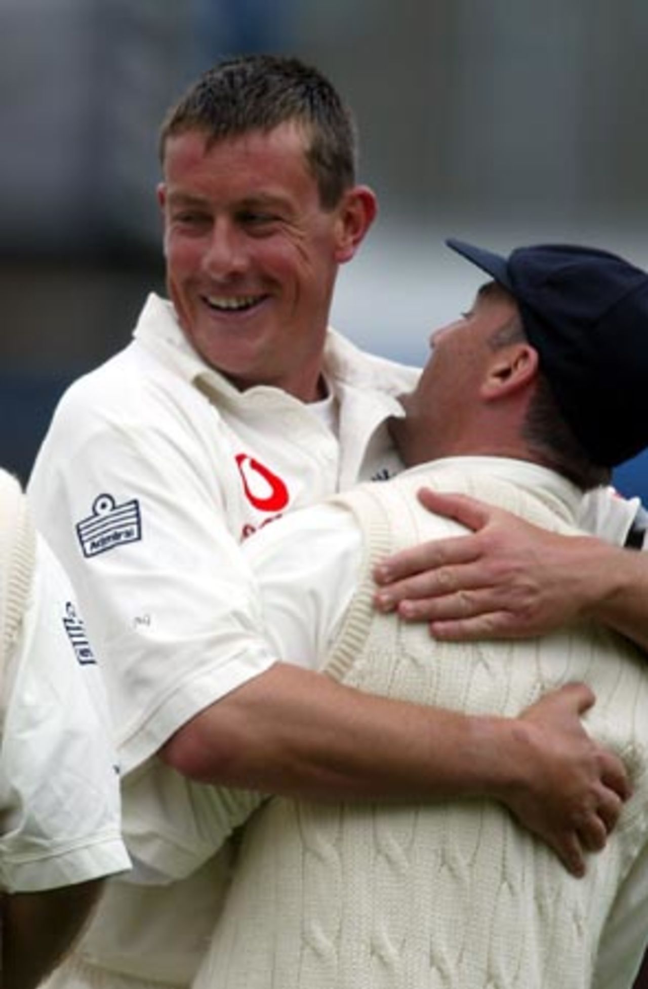 England bowler Ashley Giles (left) hugs fielder Graham Thorpe after the dismissal of New Zealand batsman Mark Richardson, caught by Thorpe for four in his second innings. 2nd Test: New Zealand v England at Basin Reserve, Wellington, 21-25 March 2002 (25 March 2002).