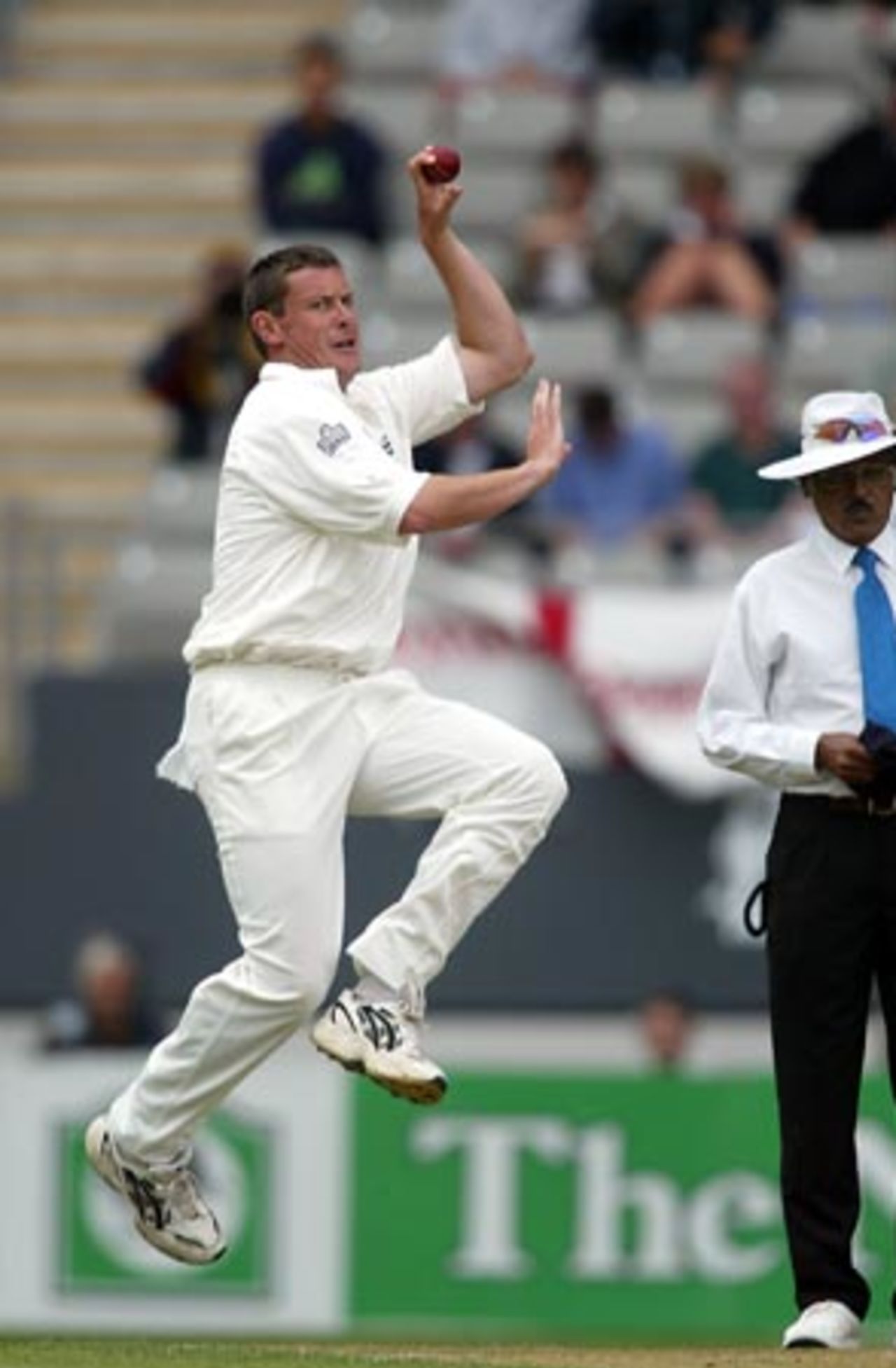 England bowler Ashley Giles delivers a ball during his first day spell of 0-1 from one over. Umpire Srinivas Venkataraghan from India looks on. 3rd Test: New Zealand v England at Eden Park, Auckland, 30 March-3 April 2002 (30 March 2002).