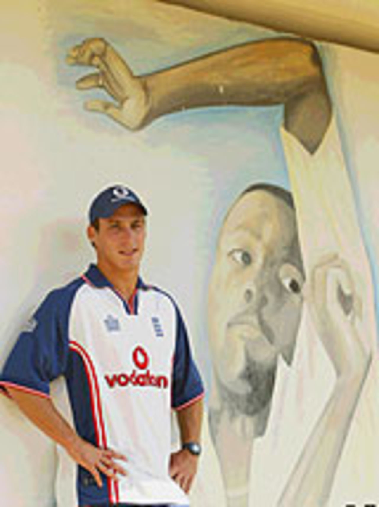 Simon Jones poses in front of a mural of Courtney Walsh, Jamaica, March 4, 2004