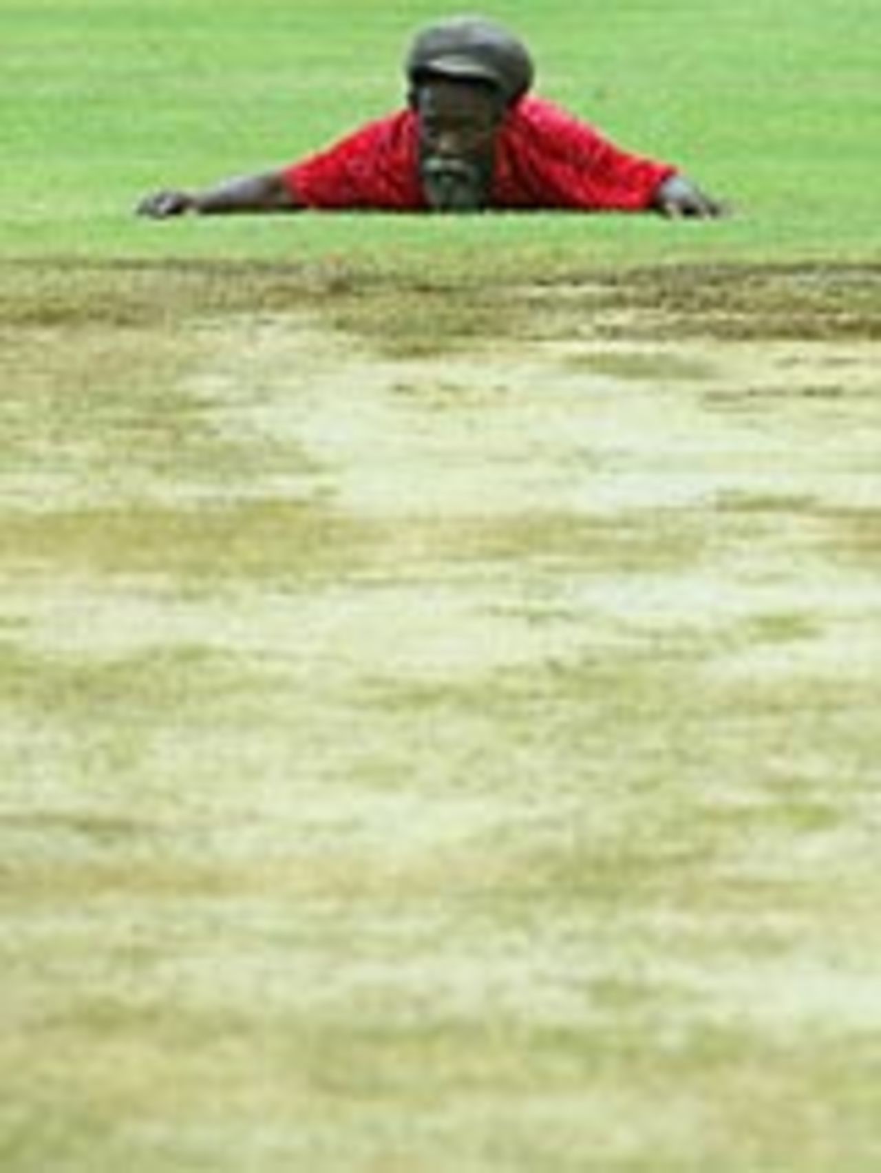 Sabina Park Groundsman Chester Martin checks the 1st Test wicket for flatness, March 7, 2004