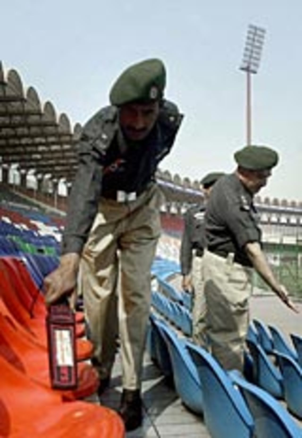 Pakistani police search the stadium at Lahore, March 10, 2004