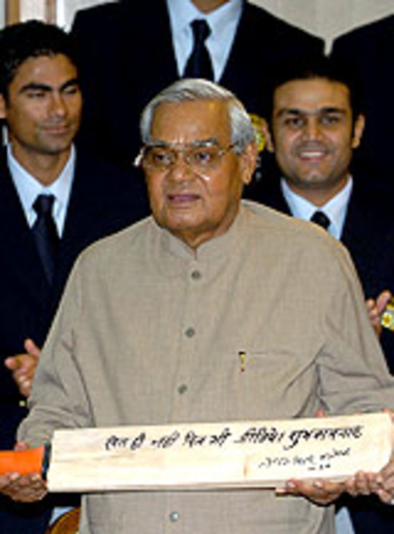 Atal Behari Vajpayee holds a cricket bat before the Indian team's departure for Pakistan, March 10, 2004