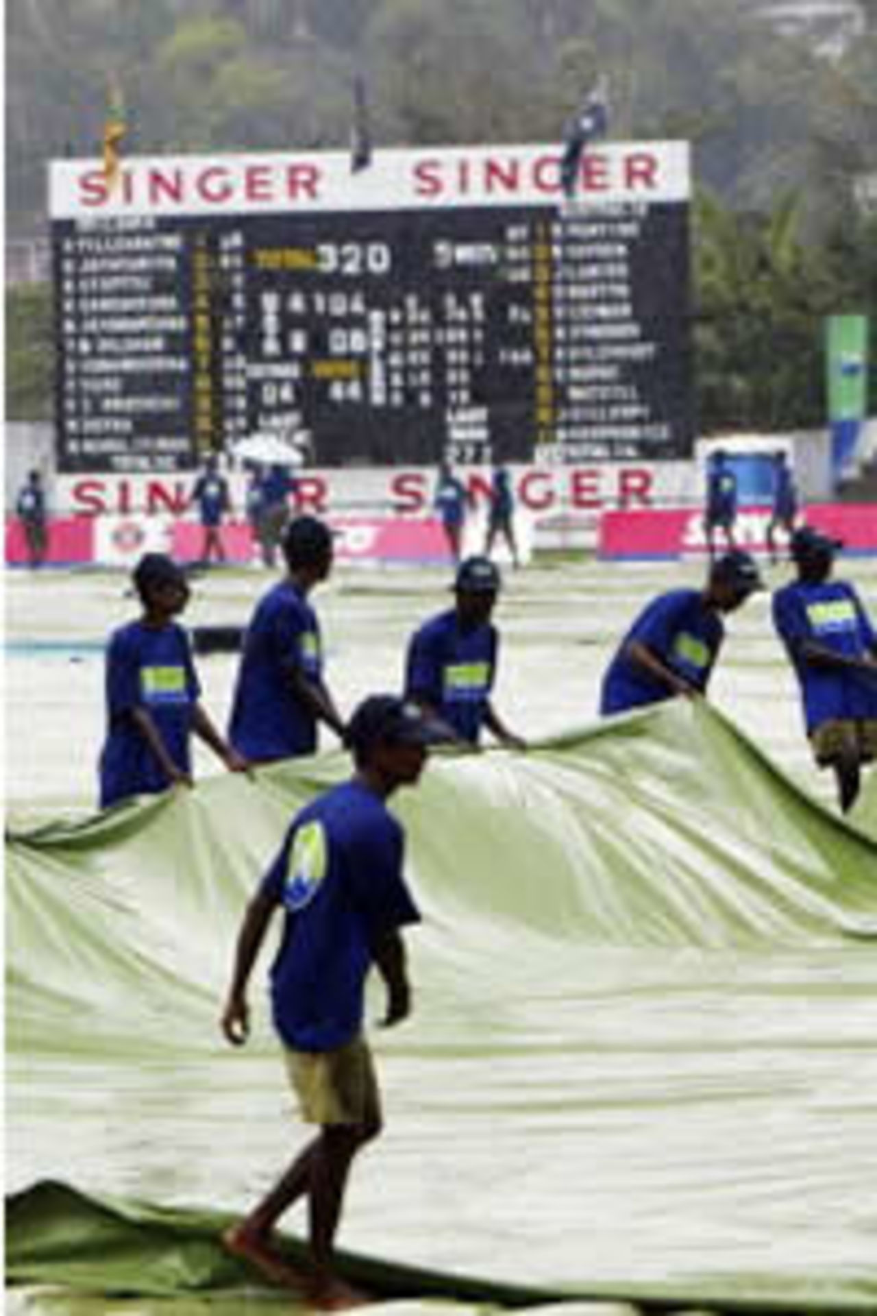 Ground staff pull out the covers as rain halts play during day three of the Second Test between Australia and Sri Lanka played at Asgiriya Stadium on March 18, 2004 in Kandy, Sri Lanka.
