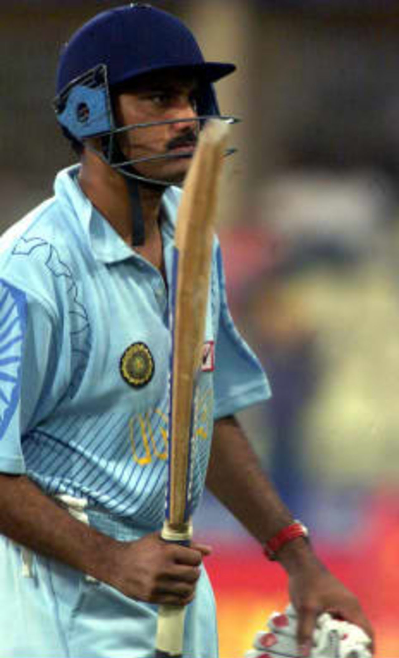 Indian captain Azharuddin acknowledges the cheers by raising his b at after having reached his half-century against England in the third match of t he Coca Cola Cup on 9th April 1999 in Sharjah