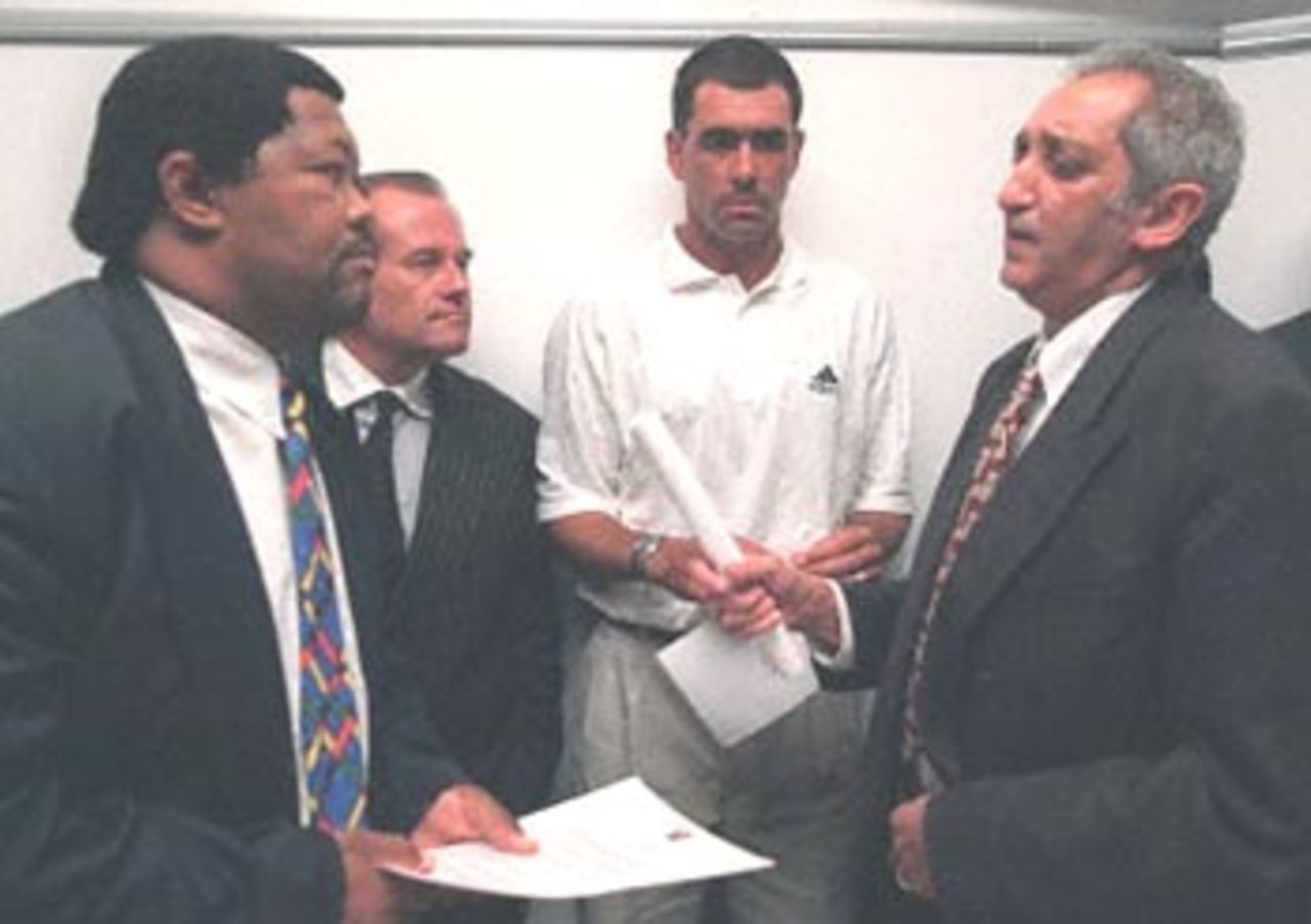Minister of Sport Balfour Ngconde (L), Pastor Ray McCauley of the Rhema Church (second from L), former South African cricket captain Hansie Cronje (second from R) and Deputy Foreign Minister Aziz Pahad chat after a press conference held in Cape Town 11 April 2000. Cronje has denied receiving money or match-fixing. He has withdrawn from the upcoming one-day tests against Australia due to be played in South Africa this week and has been stripped of his captaincy of the South African national cricket team.