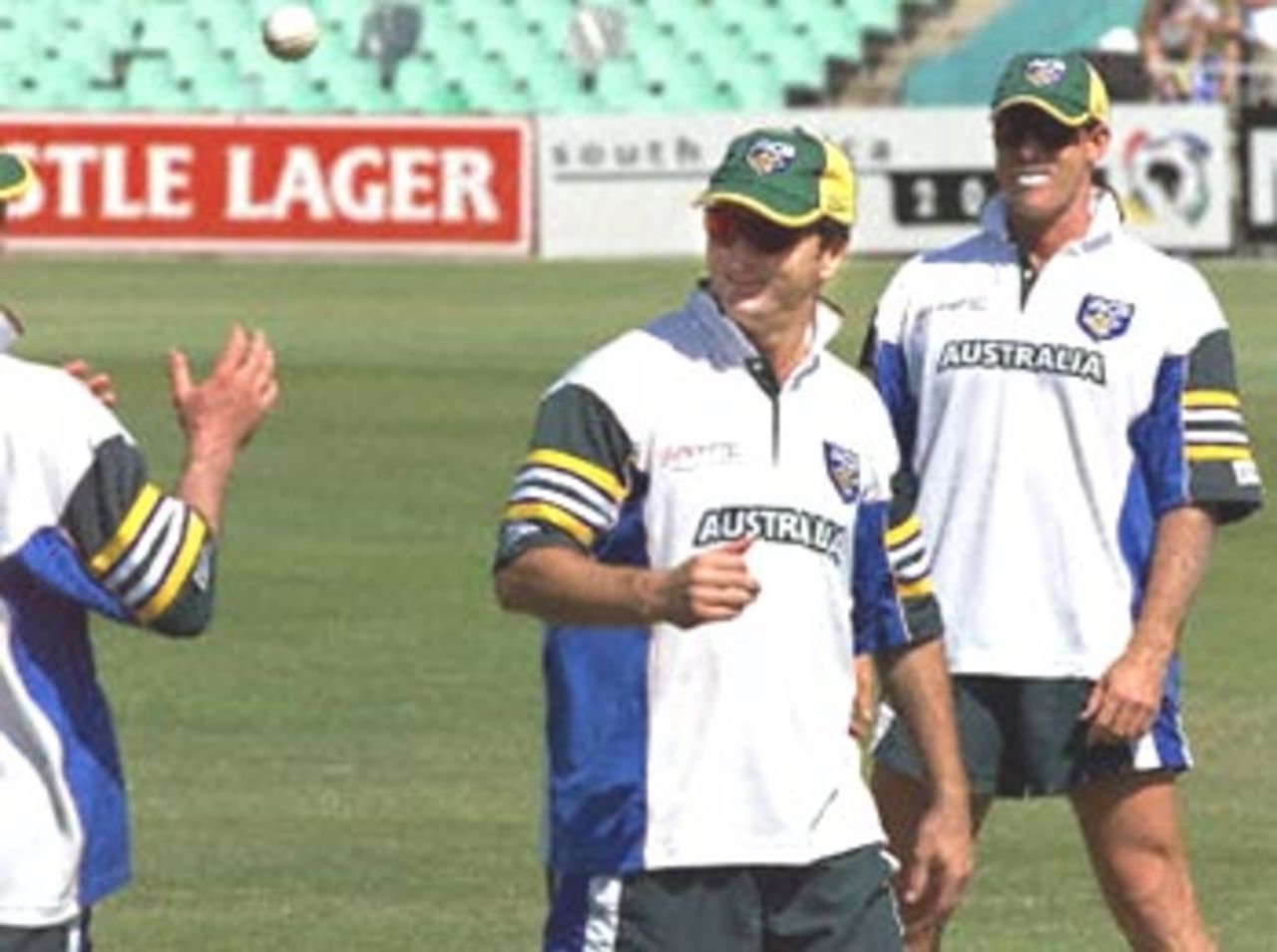 Australian cricket captain Steve Waugh (C) passes the ball watched by teammate Matthew Haydn (R) during warm up at the Kingsmead oval in Durban, 12 April 2000. The of a three one day match series between Australia and South Africa starts later today