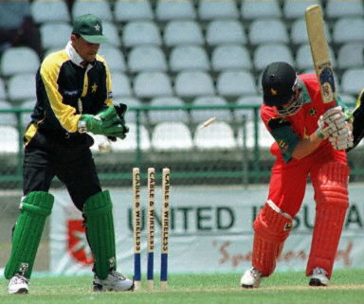 Zimbabwe batsman Stuart Carlisle (R) bowled by Pakistan's Arshad Khan during the Fifth Cable & Wireless One Day International 15 April 2000 at the New Queen's Park Stadium in Grenada