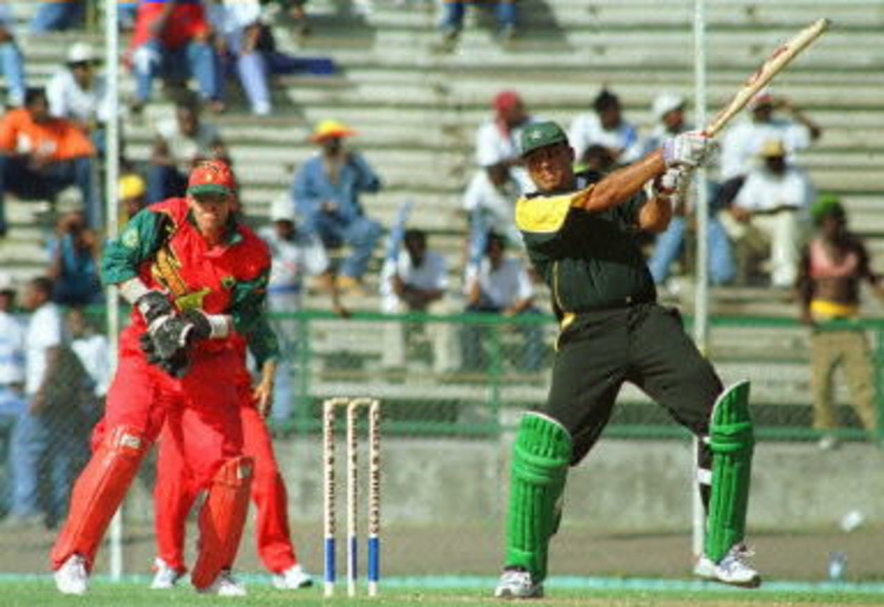 Pakistan's Inzamam-ul-Haq (R) cuts Zimbabwean bowler Grant Flower (not pictured) for 04 during the Fifth Cable & Wireless One Day International at the Queen's Park Stadium in Grenada