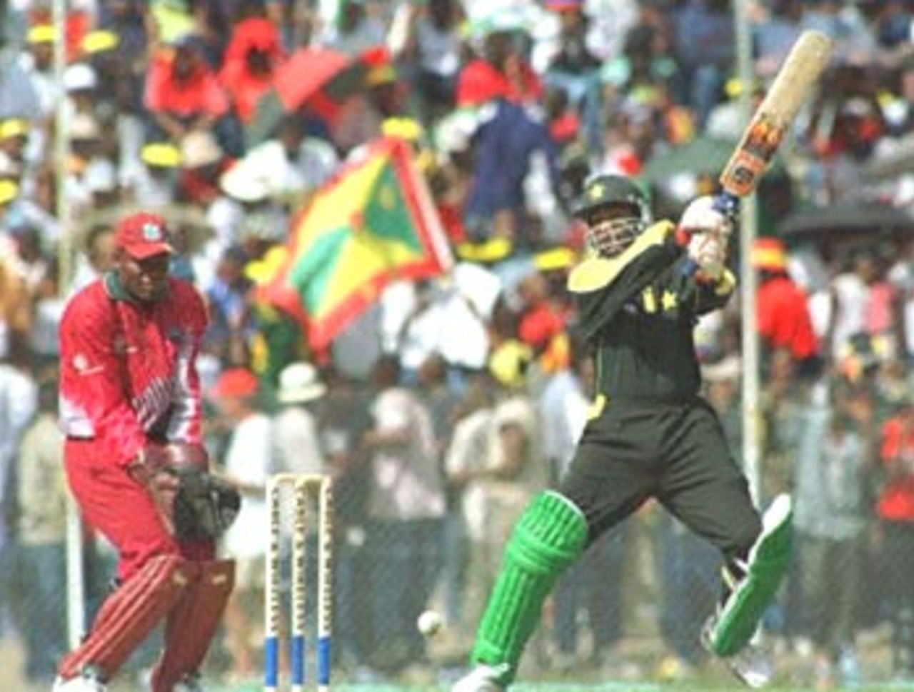 Pakistani batsman Yousuf Youhana (R) goes after the ball 16 April, 2000, during the cricket match against the West Indies at Queen's Park Stadium in St. George's, Genada. The West Indies won the match. Player at left is unidentified.
