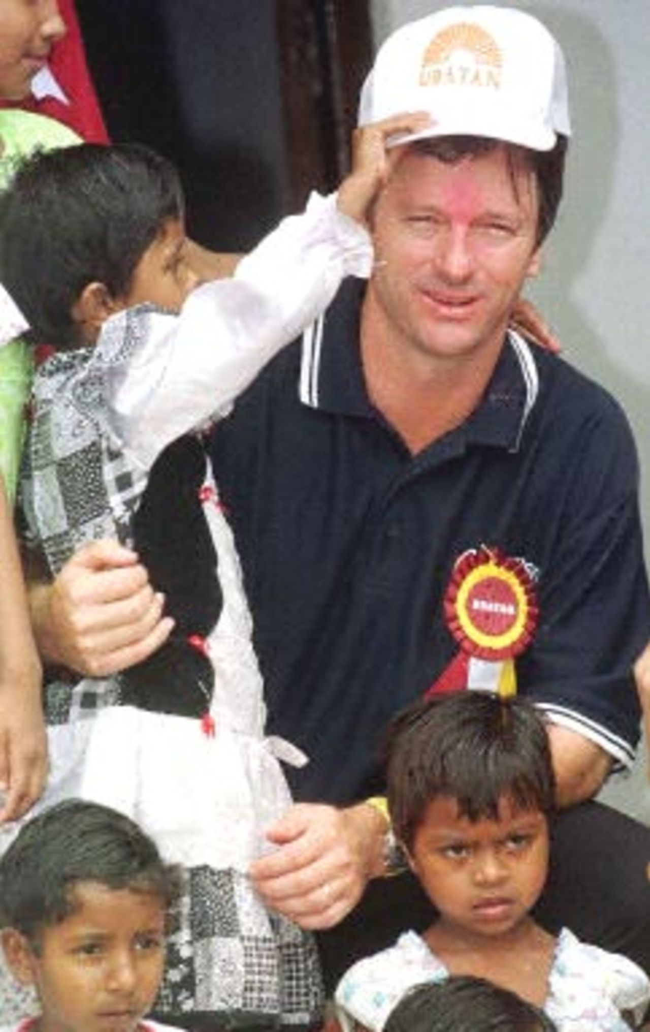 A small girl puts a cap to Steve Waugh, the Australian skipper, at Udayan a home for destitute kids in Barrackpore close to Calcutta 20 April 2000. Steve Waugh came here to open a new girls wing at Udayan and spend some time with the children. He has extended his support for the home since couple of years.