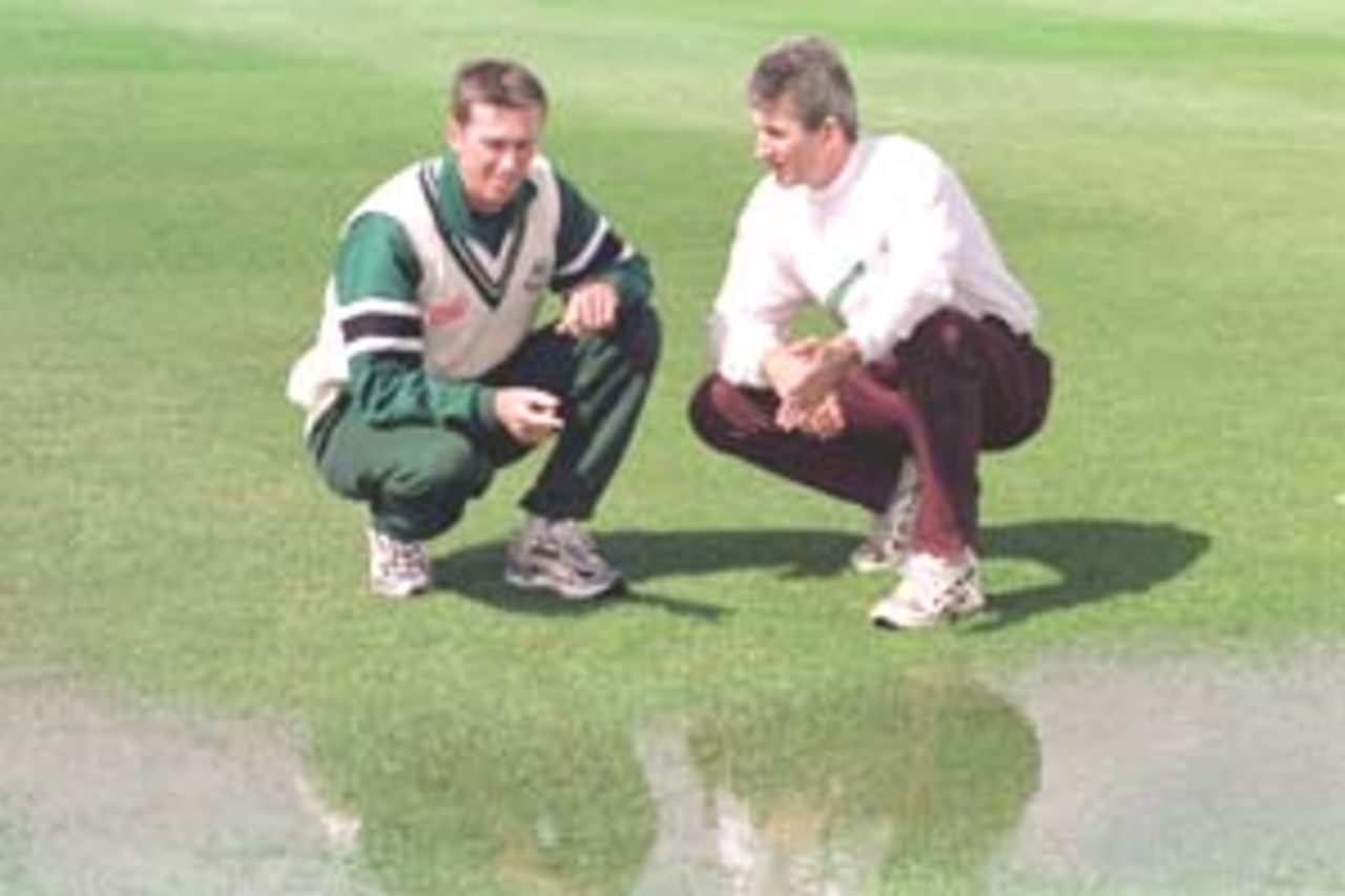 21 April 2000: Glenn McGrath of Worcestershire [left] and Andrew Caddick of Somerset inspect a rain-sodden pitch at the Benson and Hedges Cup match at Taunton in Somerset.