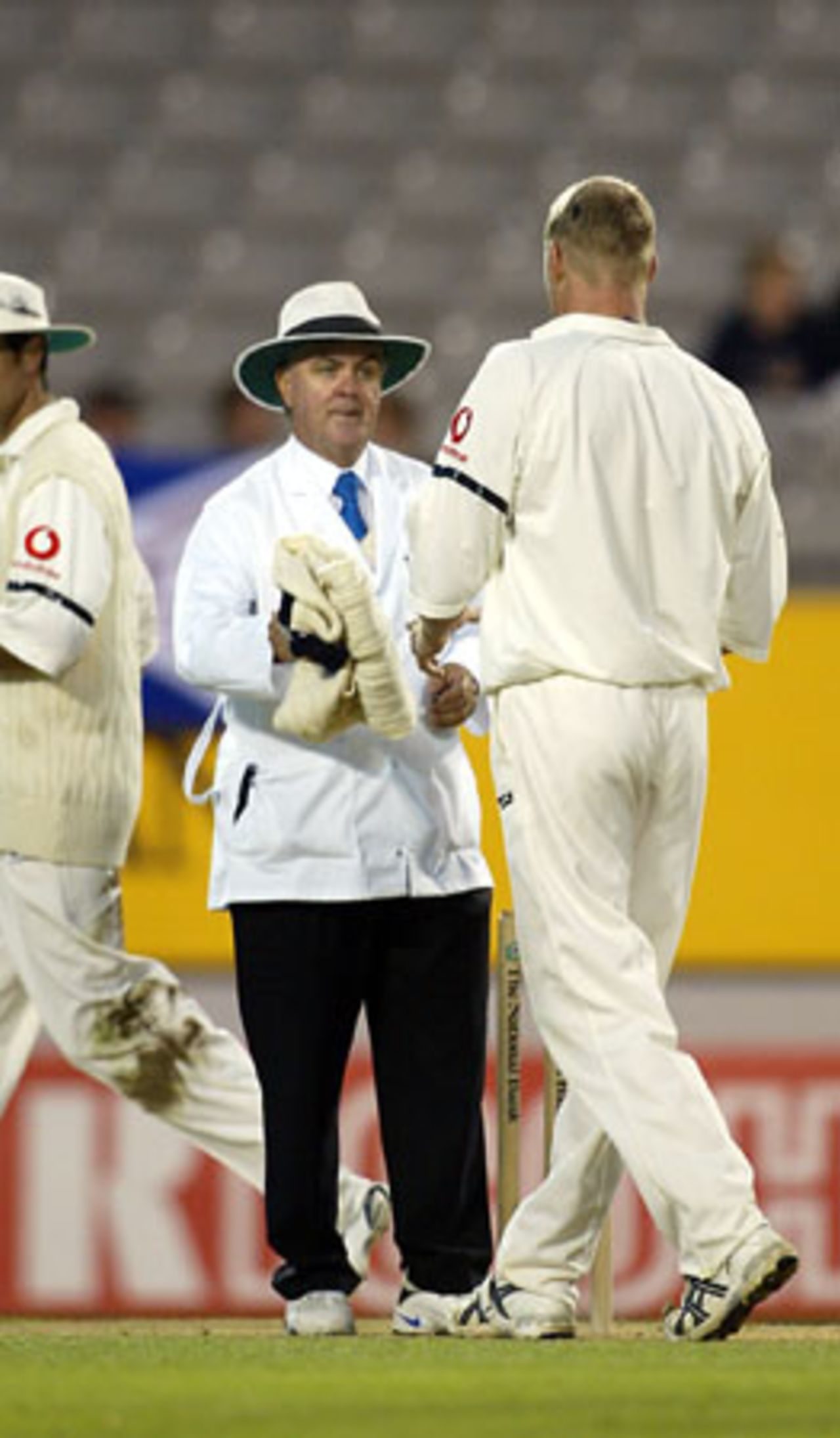 Umpire Doug Cowie hands back England bowler Andrew Flintoff his jersey at the end of an over. 3rd Test: New Zealand v England at Eden Park, Auckland, 30 March-3 April 2002 (2 April 2002).