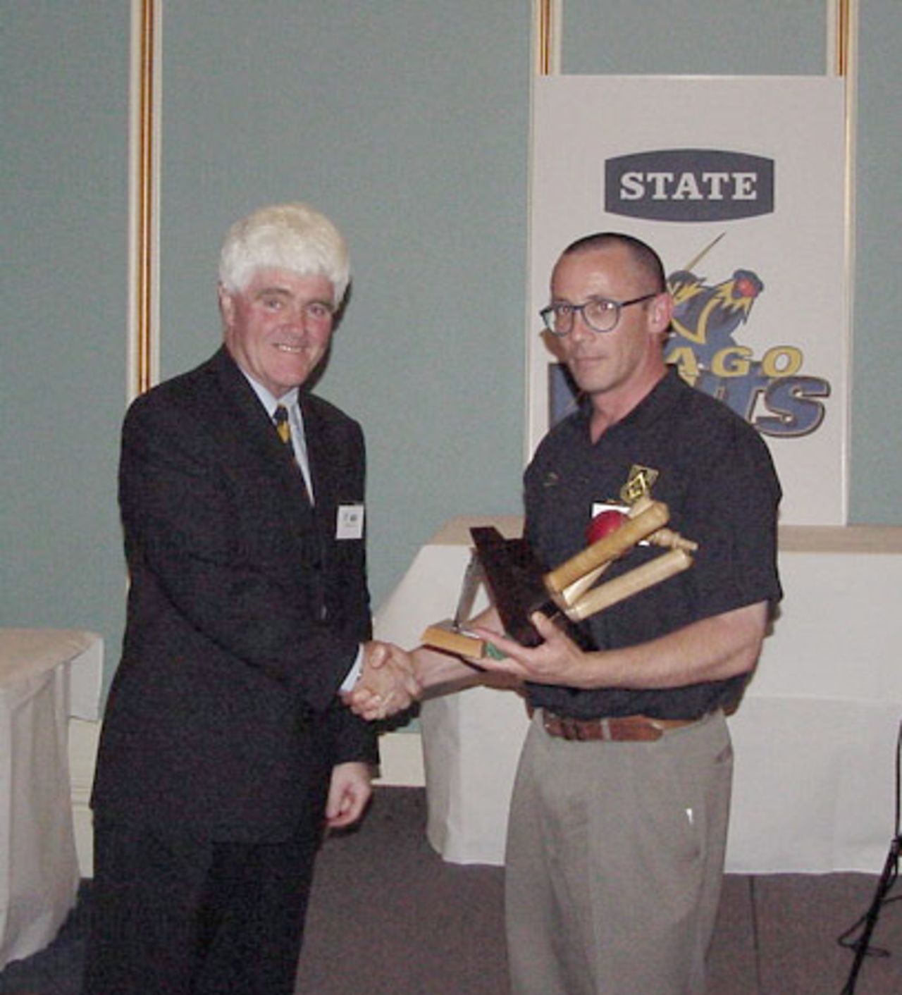George Morris (right) is presented an award for his outstanding contribution to Otago cricket by Otago Cricket Association president Warren Shirley. 9 April 2002.