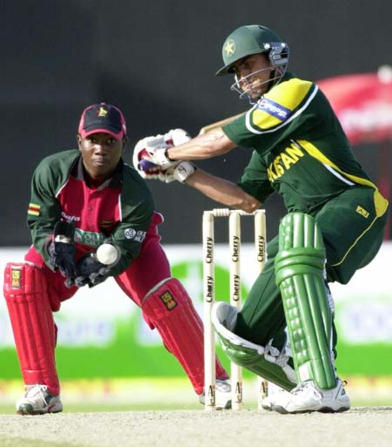 Pakistani middle order batsman Younis Khan (R) plays for a boundary as Zimbabwe wicket keeper Tatenda Taibu keeps his eyes on the ball during the first encounter of the four nation Sharjah Cricket tournament, 03 April 2003.