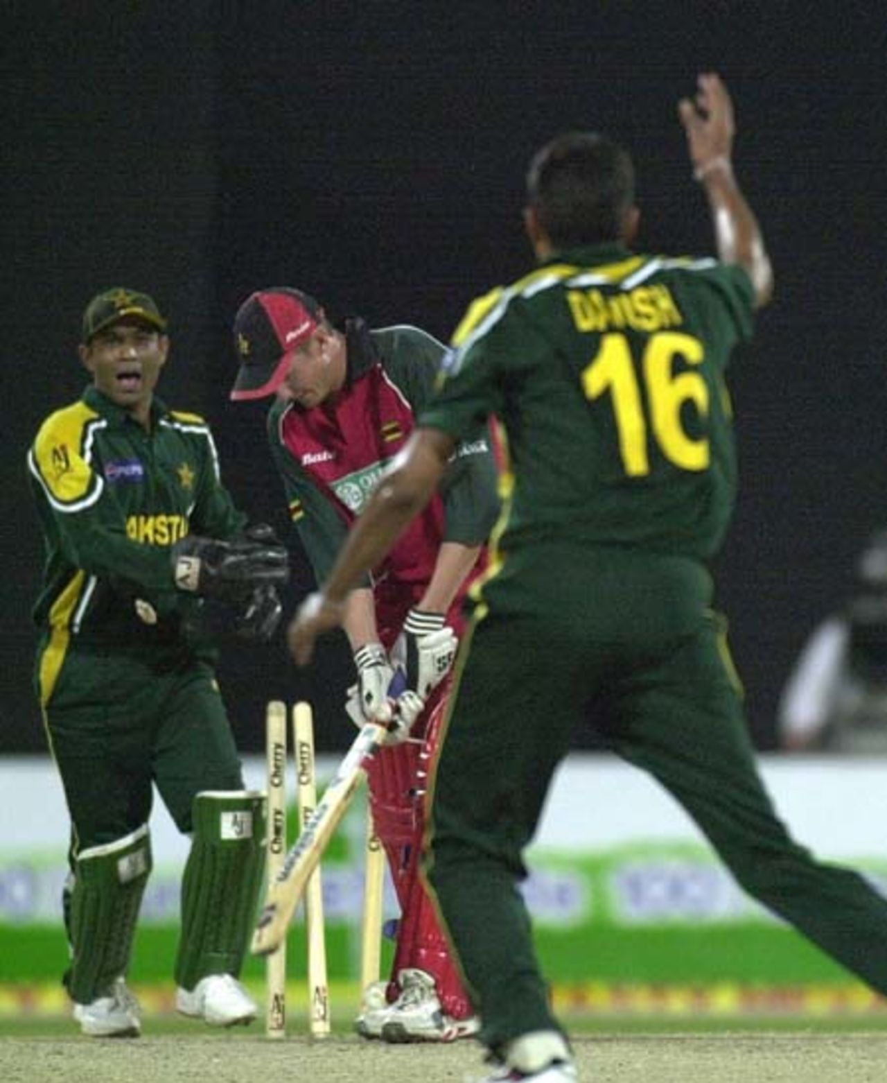 Pakistani spinner Danish Kaneria (R) and wicket keeper Rashid Latif (L) celebrate the wicket of the  Zimbabwe highest scorer Douglas Marillier during the first one-day match of the four nation Sharjah Cricket tournament, 03 April 2003.