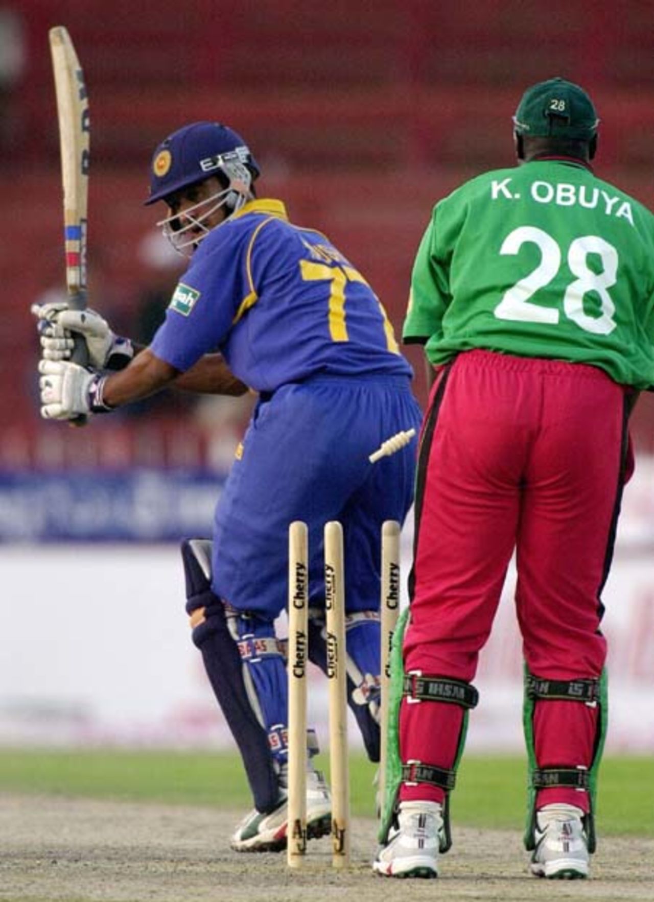 Sri Lankan batsman Kaushal Lokuarachchi (L) watches his shattered stumps off Kenyan pacer Tony Suji during the 4th one-day match in the Four Nation Sharjah Cricket Tournament, 06 April 2003.