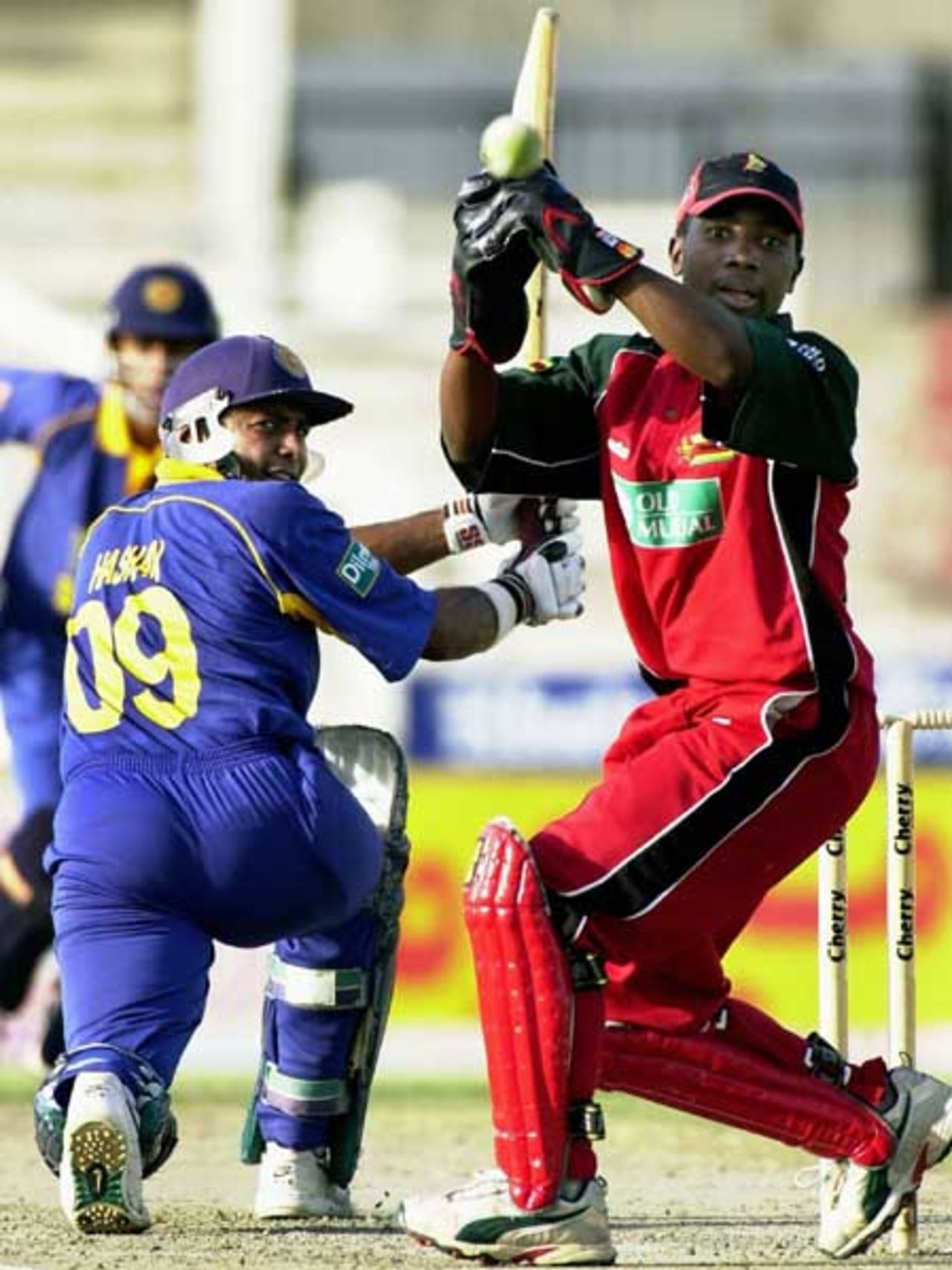 Zimbabwe wicketkeeper Tatenda Taibu (R) misses a ball played by Sri Lankan batsman Hashan Tillekratne (L) during the fifth one-day match of the Four Nation Sharjah Cricket Tournament, 07 April 2003.