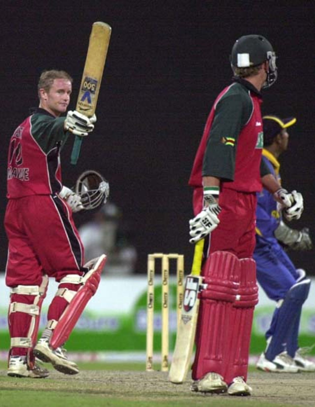 Zimbabwe top scorer Grant Flower (L) acknowledges spectators by waving his bat after decisive half century against Sri Lanka during the fifth one-day match of the Four Nation Sharjah Cricket Tournament, 07 April 2003.