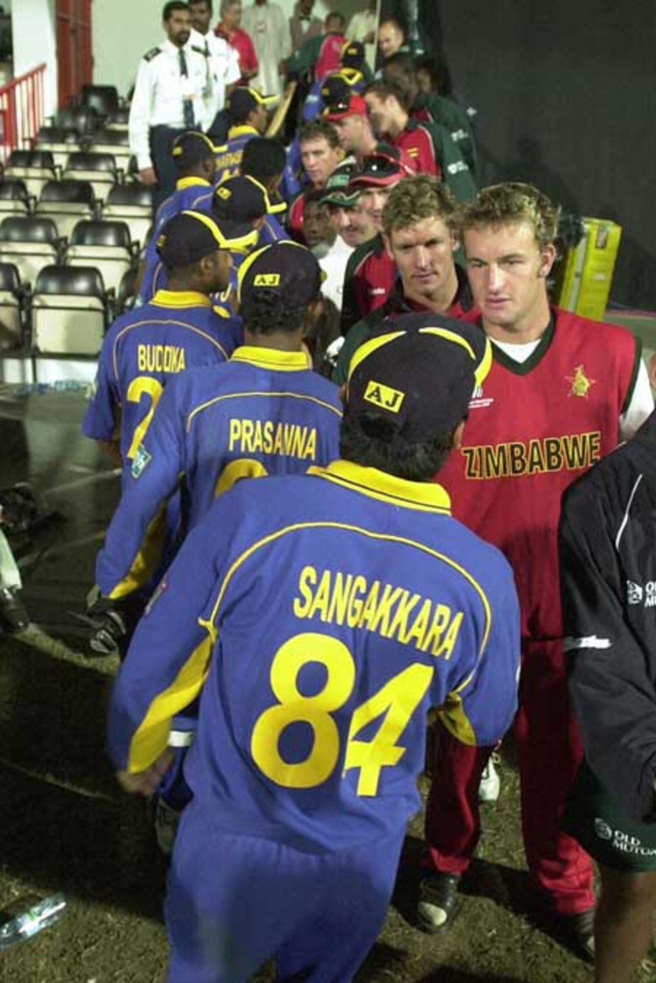 Zimbabwe team members (R) shake hands with the outgoing Sri Lankan team winning the match in the Four Nation Sharjah Cricket Tournament, 07 April 2003.