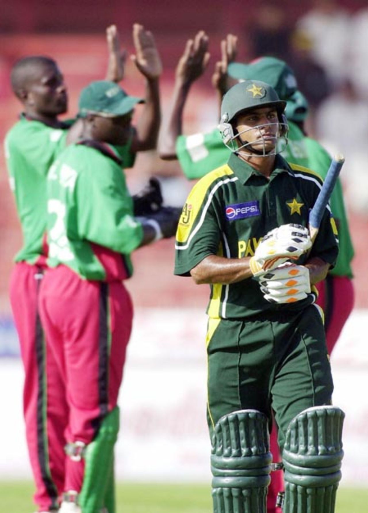 Kenyan team (L) celebrate the dismissal of Pakistani opener Muhammad Hafeez, caught out by Kennedy Obuya off Peter Ongondo, during the last match of the Four Nation Sharjah Cricket Tournament, 08 April 2003.