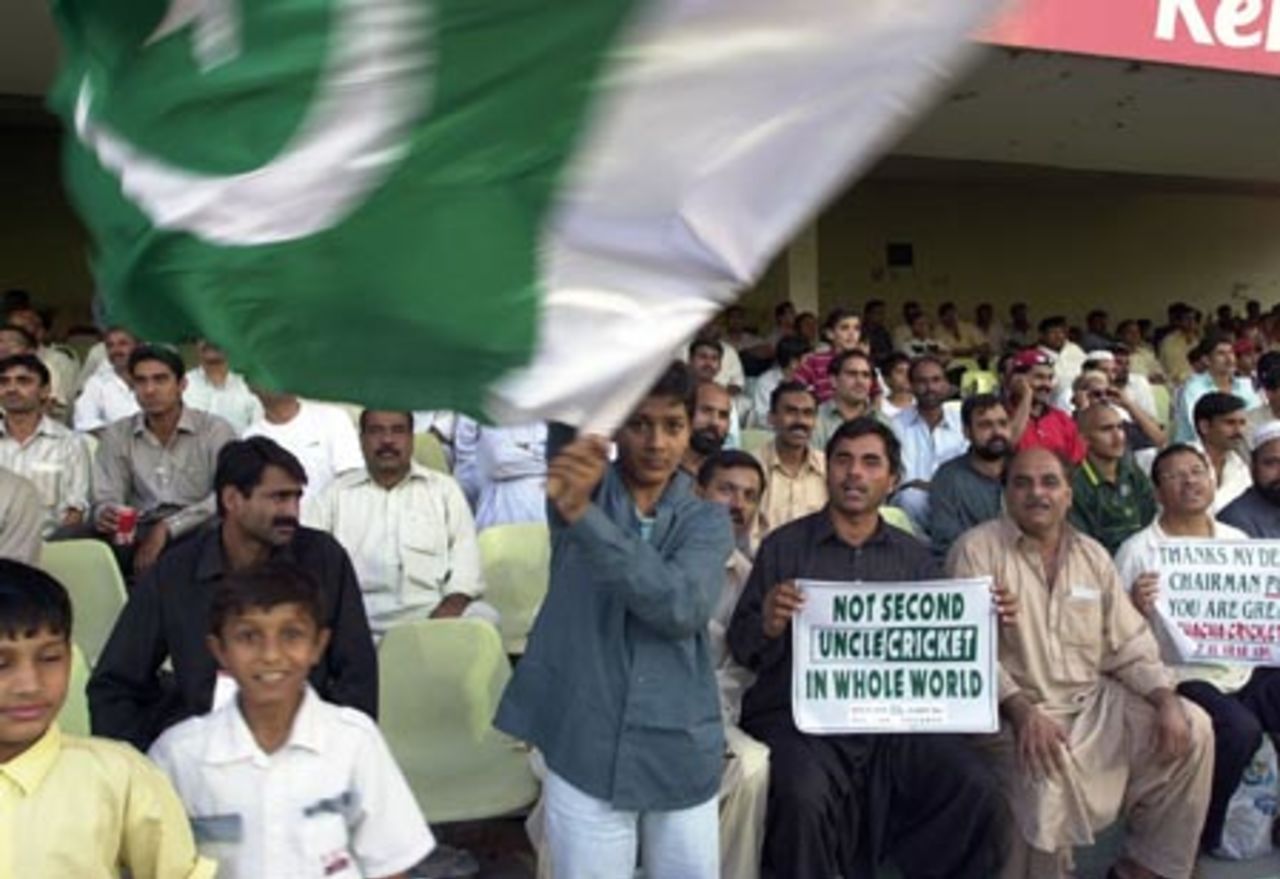 A Cricket fan waves the Pakistani flag during the sixth one day match between Pakistan and Kenya of the Four Nation Sharjah Cricket Tournament, 08 April 2003.