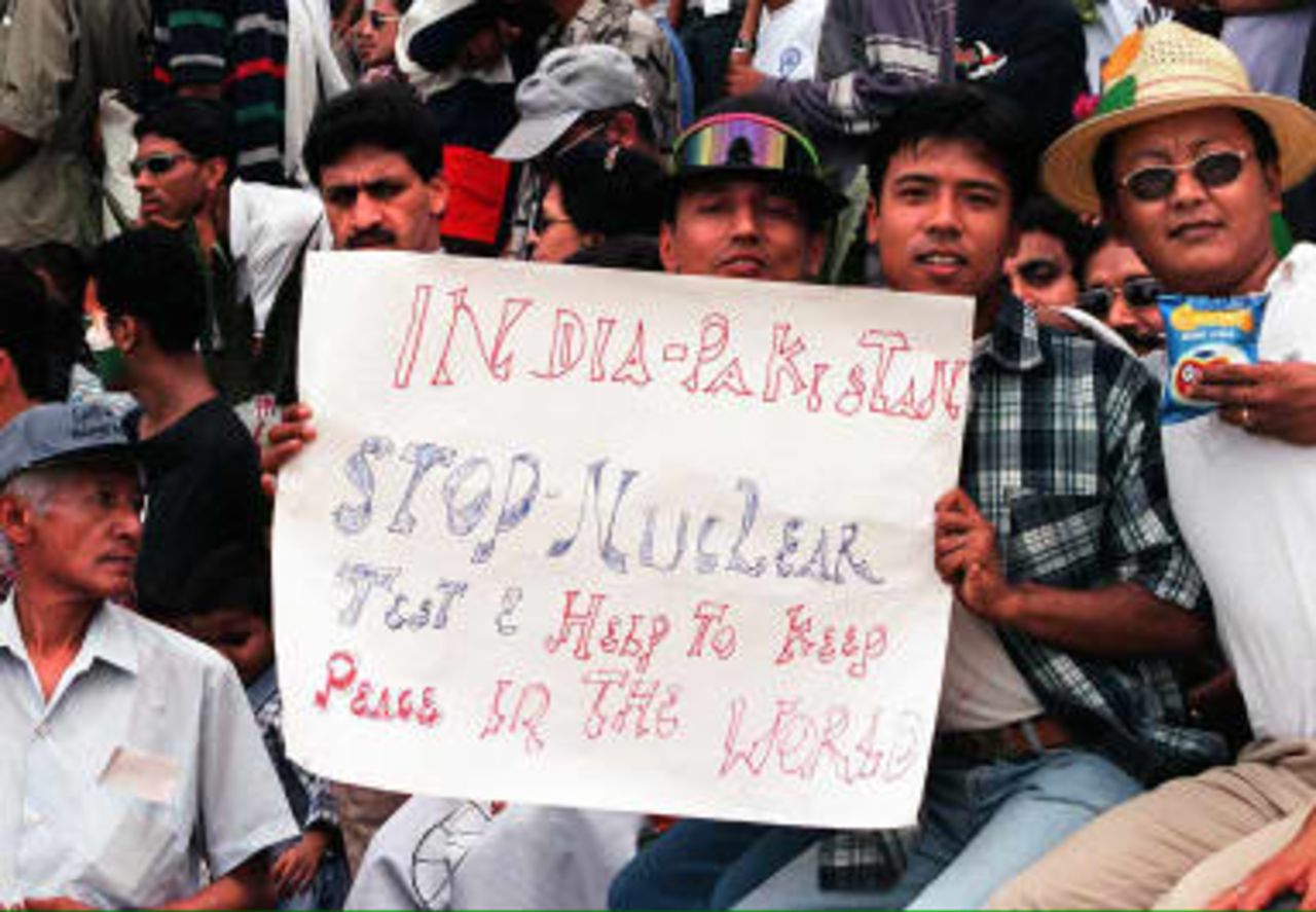 Nepalese cricket fans display a sign about the recent nuclear tests by India and Pakistan during the third day match of India vs Pakistan in the Tempo World Legends Cup cricket in Kathmandu 08 May 1999. India won by 30 runs in the match.