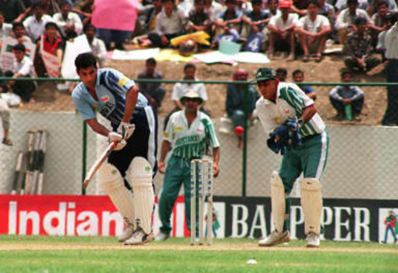 Indian batsman Atul Wasson (L) and Pakistani wicketkeeper Tahir Rasheed (R) are seen in action on the third day of the Tempo World Legends Cup cricket match in Kathmandu 08 May 1999.  India beat Pakistan by 30 runs