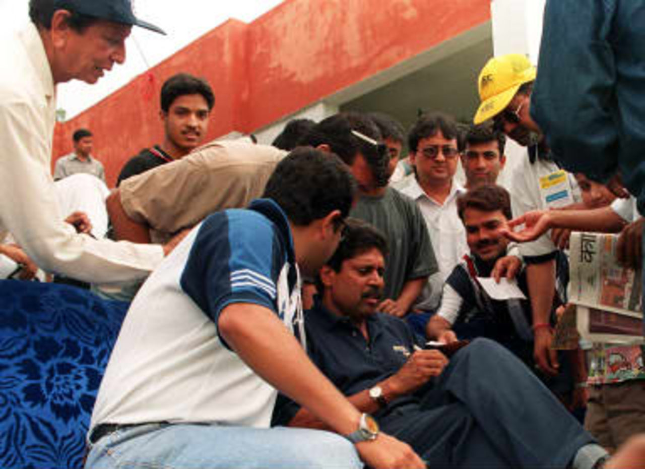 Former Indian cricket captain Kapil Dev (C) gives autographs to fans during the opening of the Tempo Word legends Cup in Kathmandu 06 May 1999.