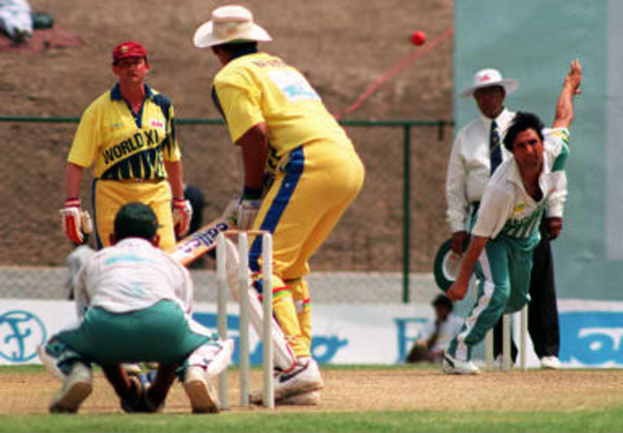 Pakistani captain and legspin bowler Abdul Qadir (R) bowling during the Tempo World Legends Cup cricket match with World XI in Kathmandu 07 May 1999. Team World XI beat Pakistan by 15 runs. The other players are unidentified.