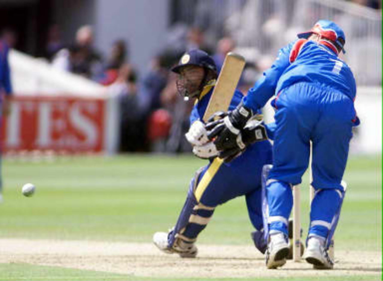 Sri Lankan batsman Romesh Kaluwitharana (L) hits out against England as the England captain Alec Stewart looks on, during their opening Cricket World Cup match against Sri Lanka at Lord's in London 14 May 1999.  Kaluwitharana was later out for 52, caught Stewart.