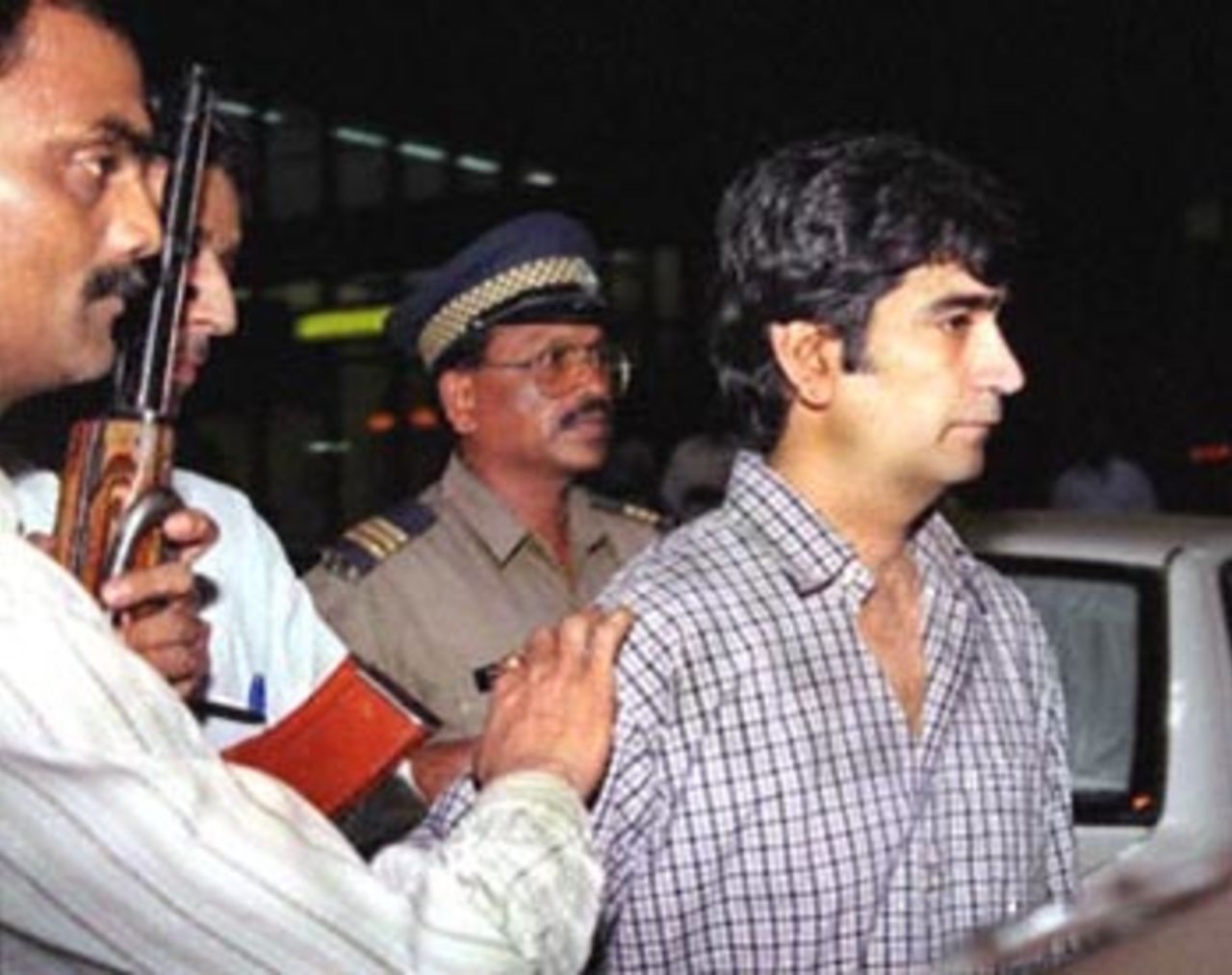 Indian film actor Kishan Kumar (R), one of the men accused in the cricket match-fixing scandal, is taken by a special police squad to the crime branch headquarters in Mumbai for investigation 05 May 2000. The scandal, which has already brought down South African cricket captain Hansie Cronje, has also rocked the Indian cricket team with the coach and former player Kapil Dev being accused of having offered a bribe to then teammate Manoj Prabhakar during their playing days.