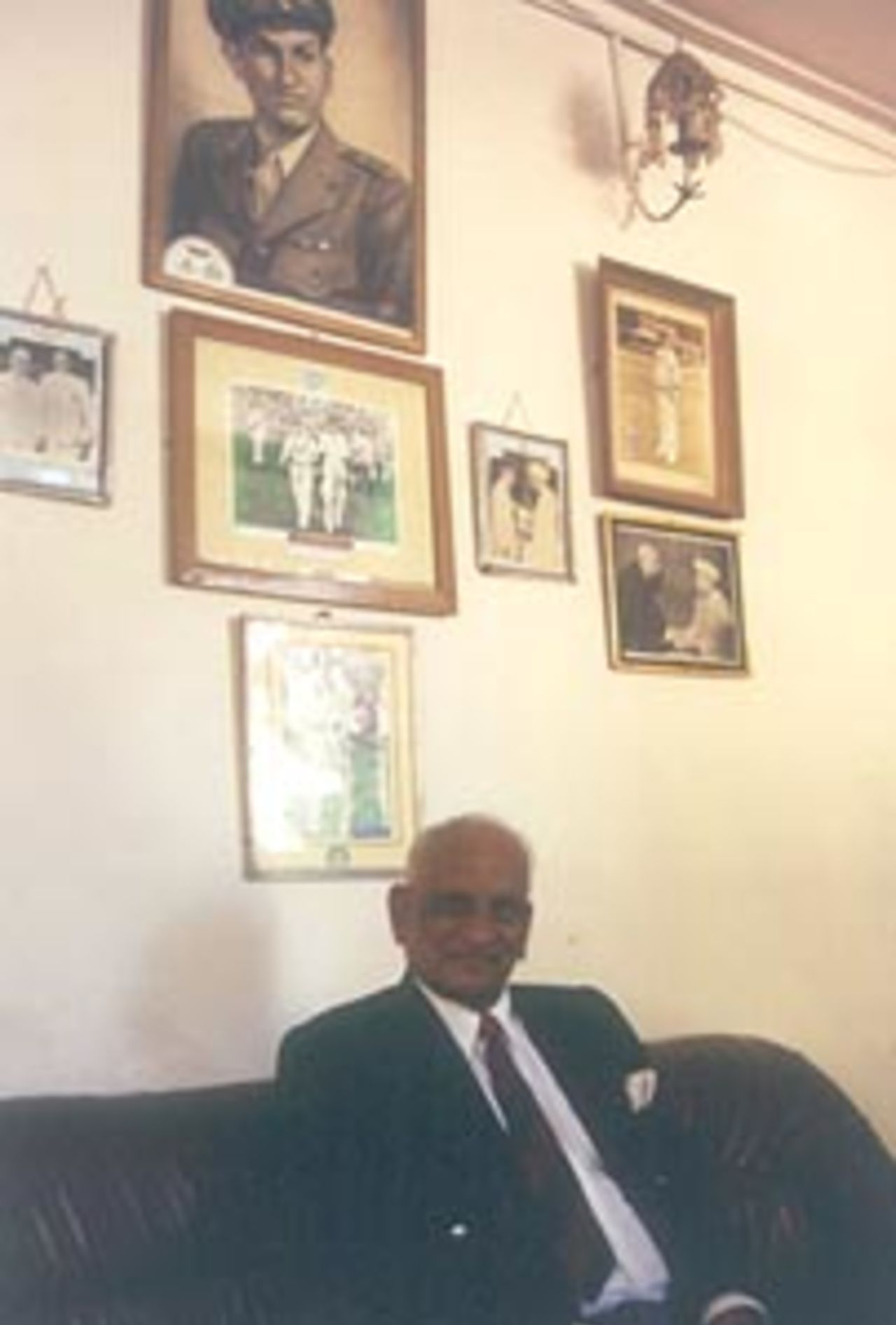Mushtaq Ali poses in front of pictures taken during his playing days, Indore, December 1999