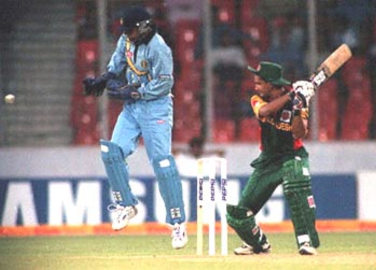 India's stand-in wicket-keeper Rahul Dravid (L) takes evasive action as Bangladeshi batsman Hasibul Basher cuts during his innings of 45 not out in the four-nation Asia Cup limited-overs tournament at the Bangabandhu national stadium in Dhaka 30 May 2000. Dravid kept wickets after Saba Karim was injured. Rain washed out play after Bangladesh were 98 for two in 25.2 overs. The match will resume 31 May. Asia Cup 1999/00, 2nd Match, Bangladesh v India, Bangabandhu National Stadium, Dhaka