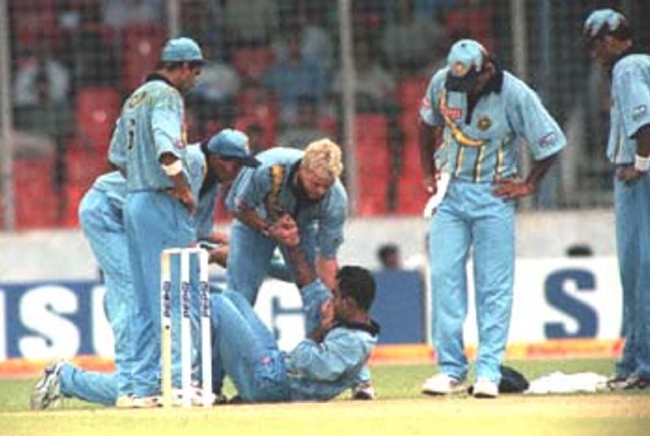 Indian players watch anxiously as wicket-keeper Saba Karim is helped up after being hit in the face by a ball from Indian bowler Anil Kumble during the Asia Cup limited-overs international against in Dhaka 30 May 2000. Karim was taken to a local hospital and vice-captain Rahul Dravid donned the gloves. The match was washed out by rain after Bangladesh were 98 for two in 25.2 overs, with play to resume 31 May. Asia Cup 1999/00, 2nd Match, Bangladesh v India, Bangabandhu National Stadium, Dhaka 30 May 2000
