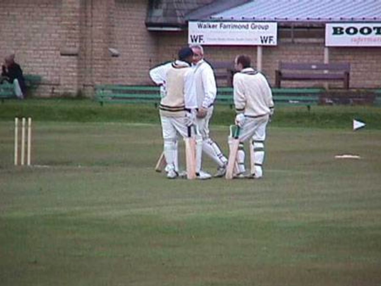 Nasir Iqbal, injured Jean Van Boeckel and runner Andy Clague discuss tactics before the start of the last over against Bacup